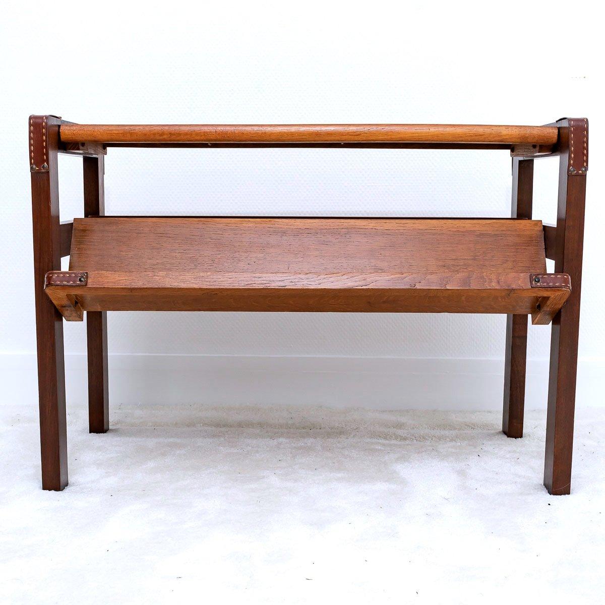Coffee table forming magazine rack of Jacques Adnet.
The structure in elm decorated with leather.

He directed the Compagnie des Arts Français from 1928 to 1960. His furniture with a refined design, incorporating mirrors, parchment, leather and