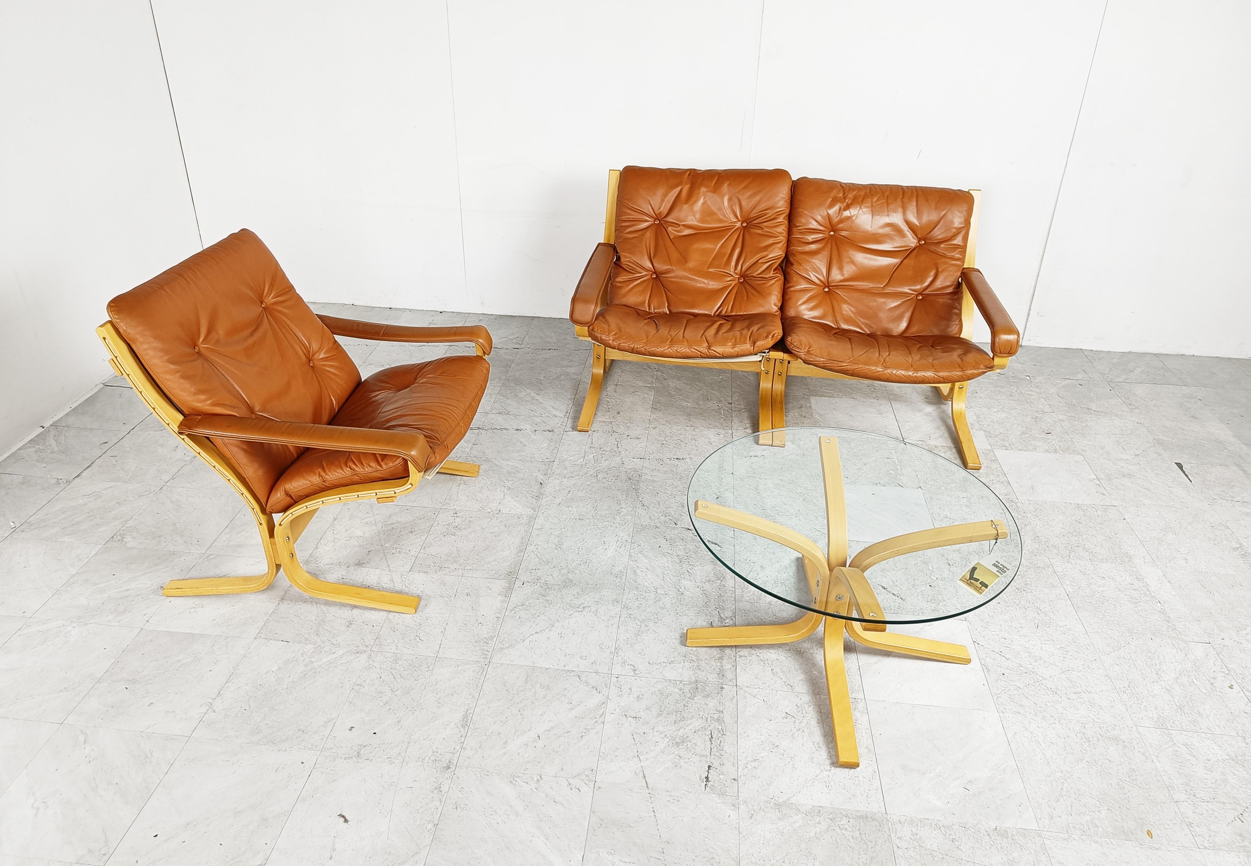 Vintage living room set designed by Ingmar Relling for Westnofa.

Beech wooden frames with brown leather cushions.

The sets consists of a two seater bench, armchair and a coffee table.

The original label is still there.

Very good and
