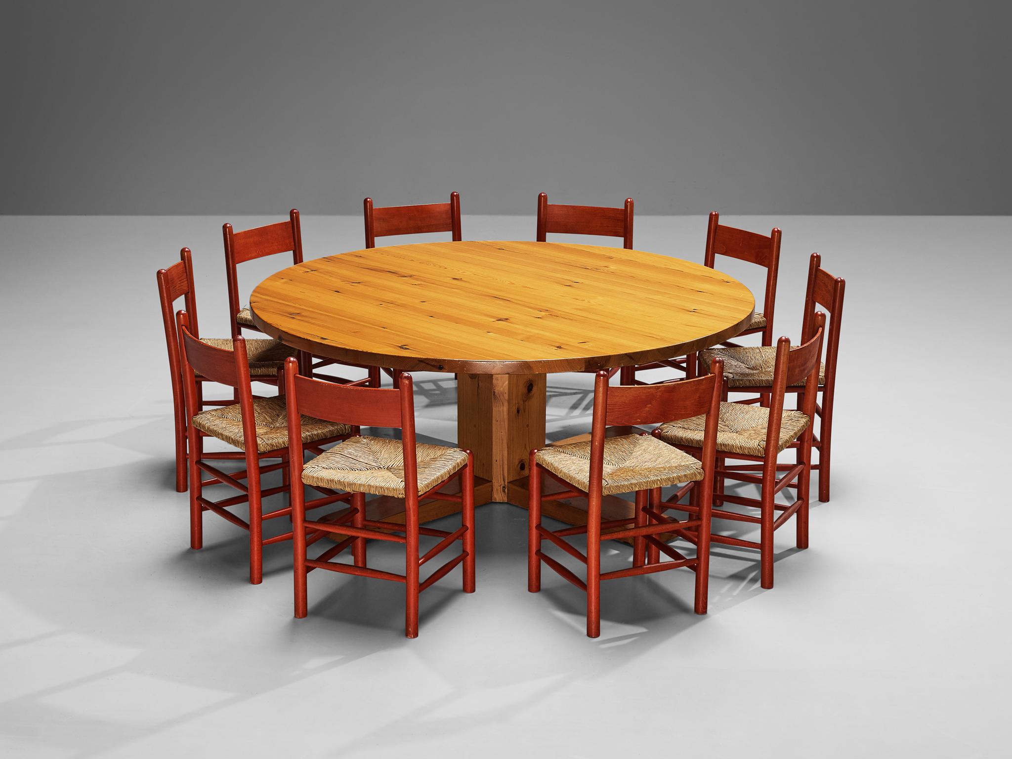 Lovely dining room set consisting a large Spanish table in solid pine and ten French dining chairs in red lacquered beech and straw seats. 

Large dining table, solid pine, Spain, 1950s

This remarkable table holds a strong expression due to several