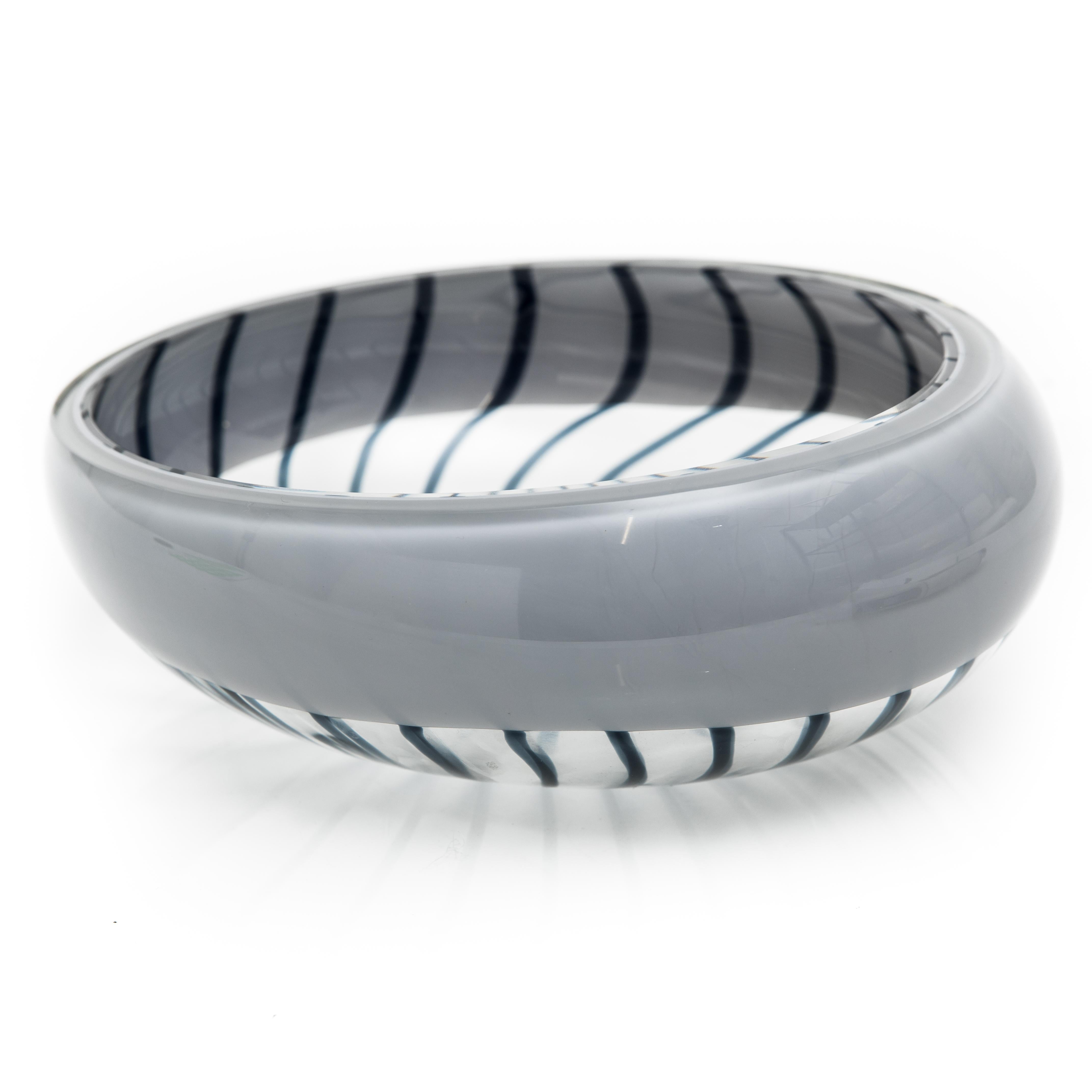 Offered is a Livio Seguso 20th century modern Murano striped art glass bowl. The glass is clear painted with a grey rim and decorated with dark blue stripes. The Bowl is signed on the bottom 
