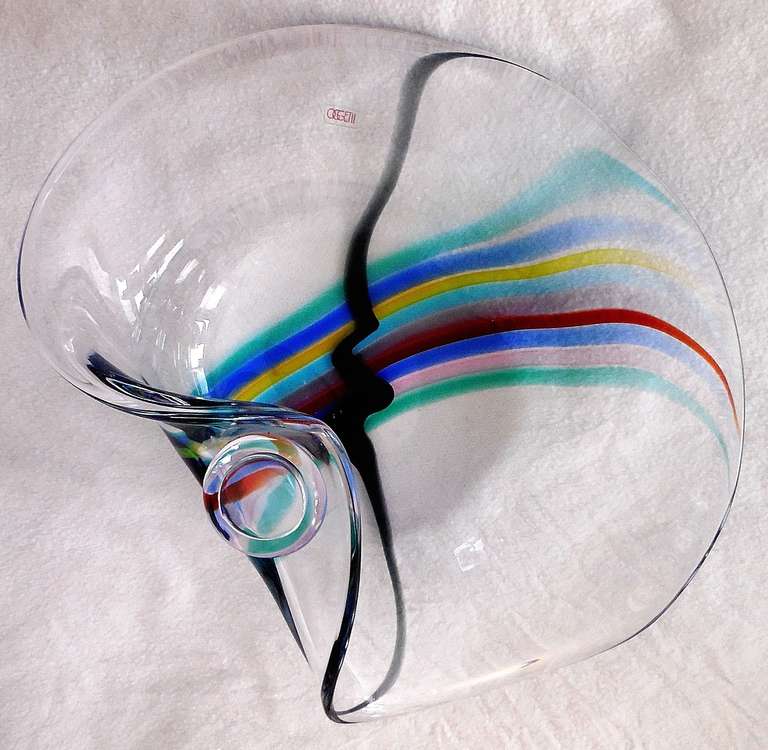 A huge centerpiece good-quality Seguso Murano (probably 1970s or 1980s, Memphis Milano era) elliptical-form clear glass sculptural bowl with striated rainbow colors of blue, orange, pink, red, yellow and green; the thick clear glass bowl with layers