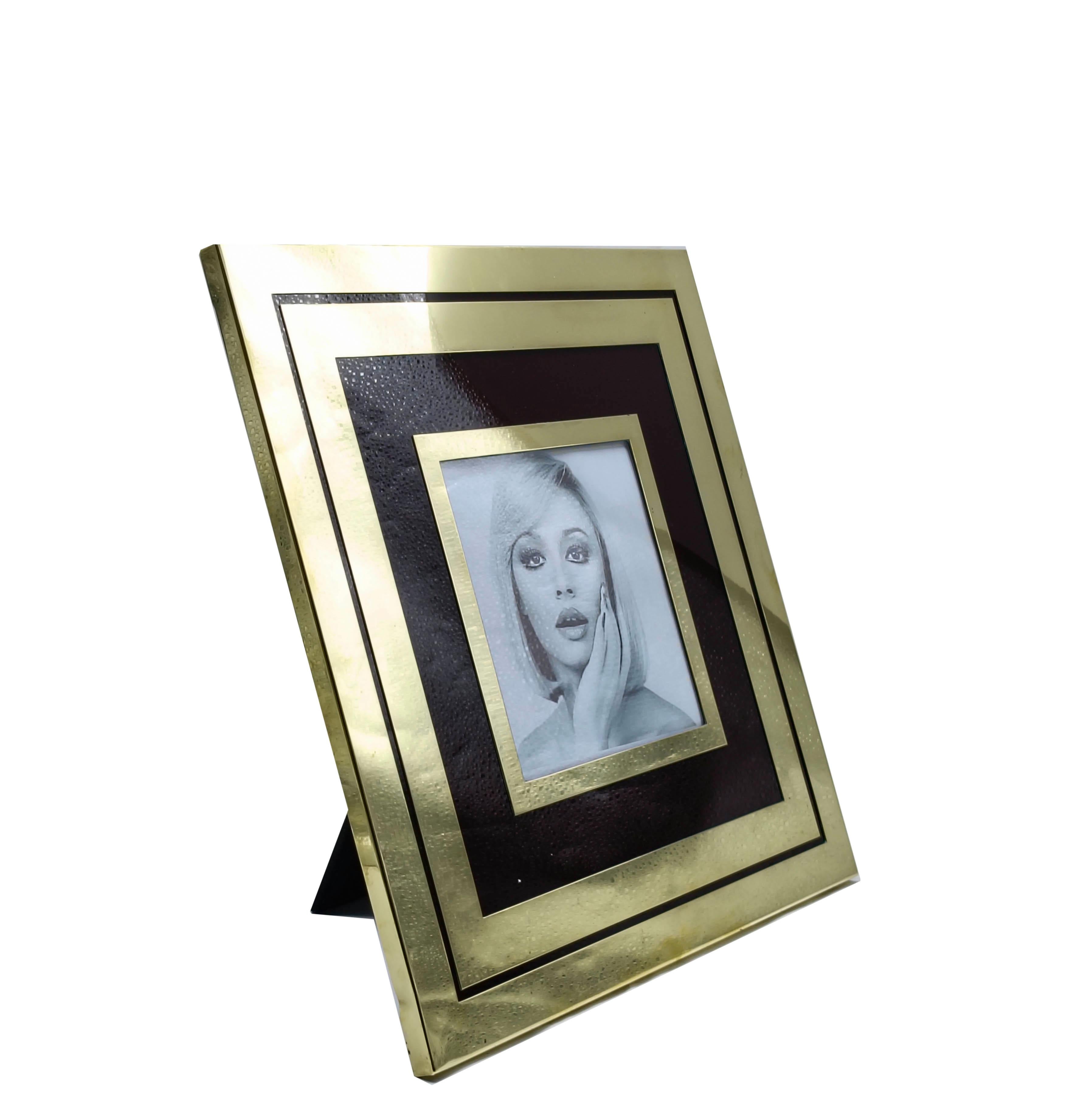 Italian frame of Liwan's from the 1970s. The frame features a distinctive geometric design with a combination of brass and lacquer tones . Its sleek, modernist style and high-quality metal frame reflect the elegant and innovative aesthetic of the