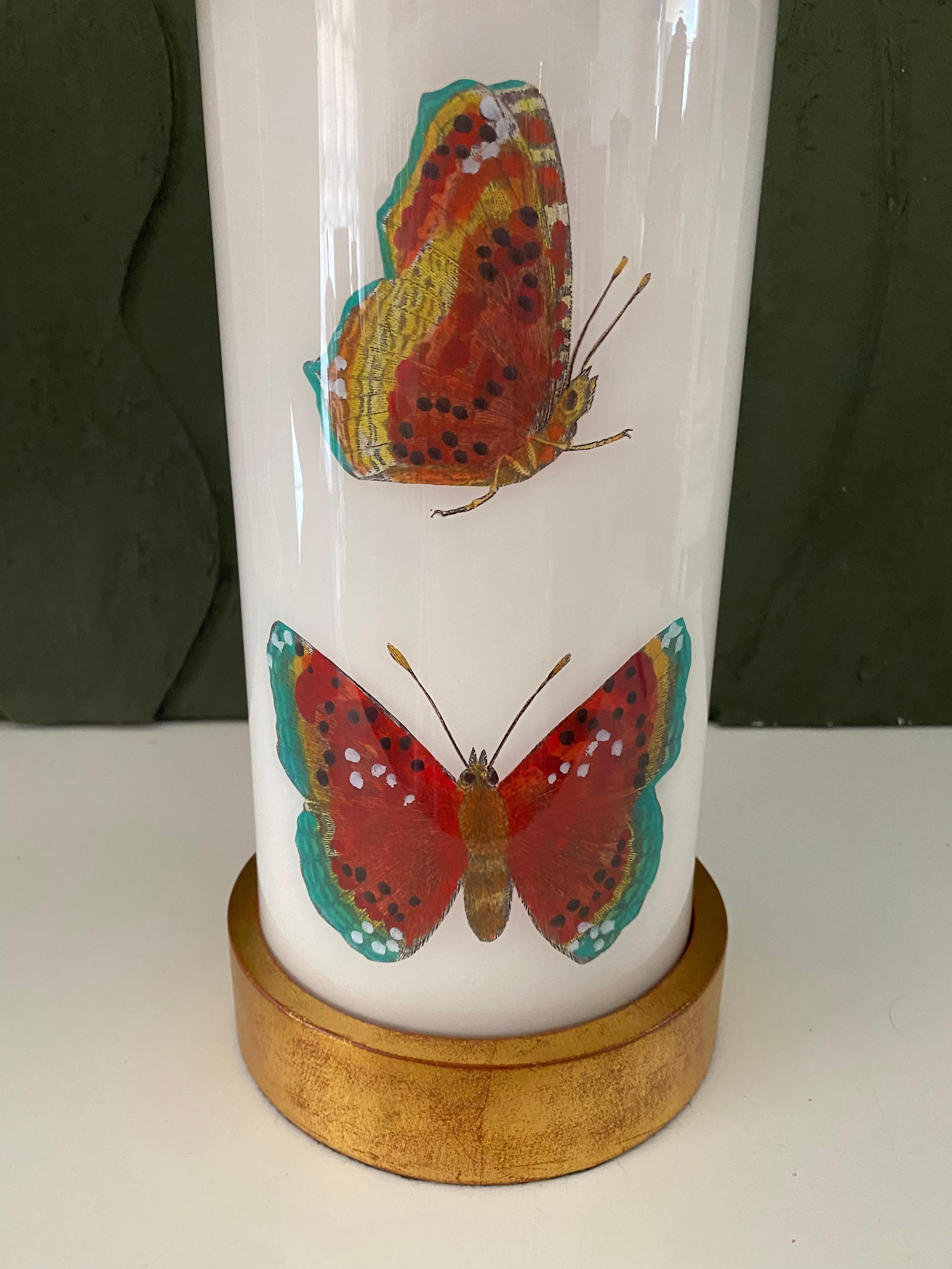 Hand made with care in Houston, Texas. This glass lamp features a selection of 18th century hand-colored engravings of beautiful insects in terracotta red hues against a soft white background, with hand-turned lightly distressed, gilt wood base and