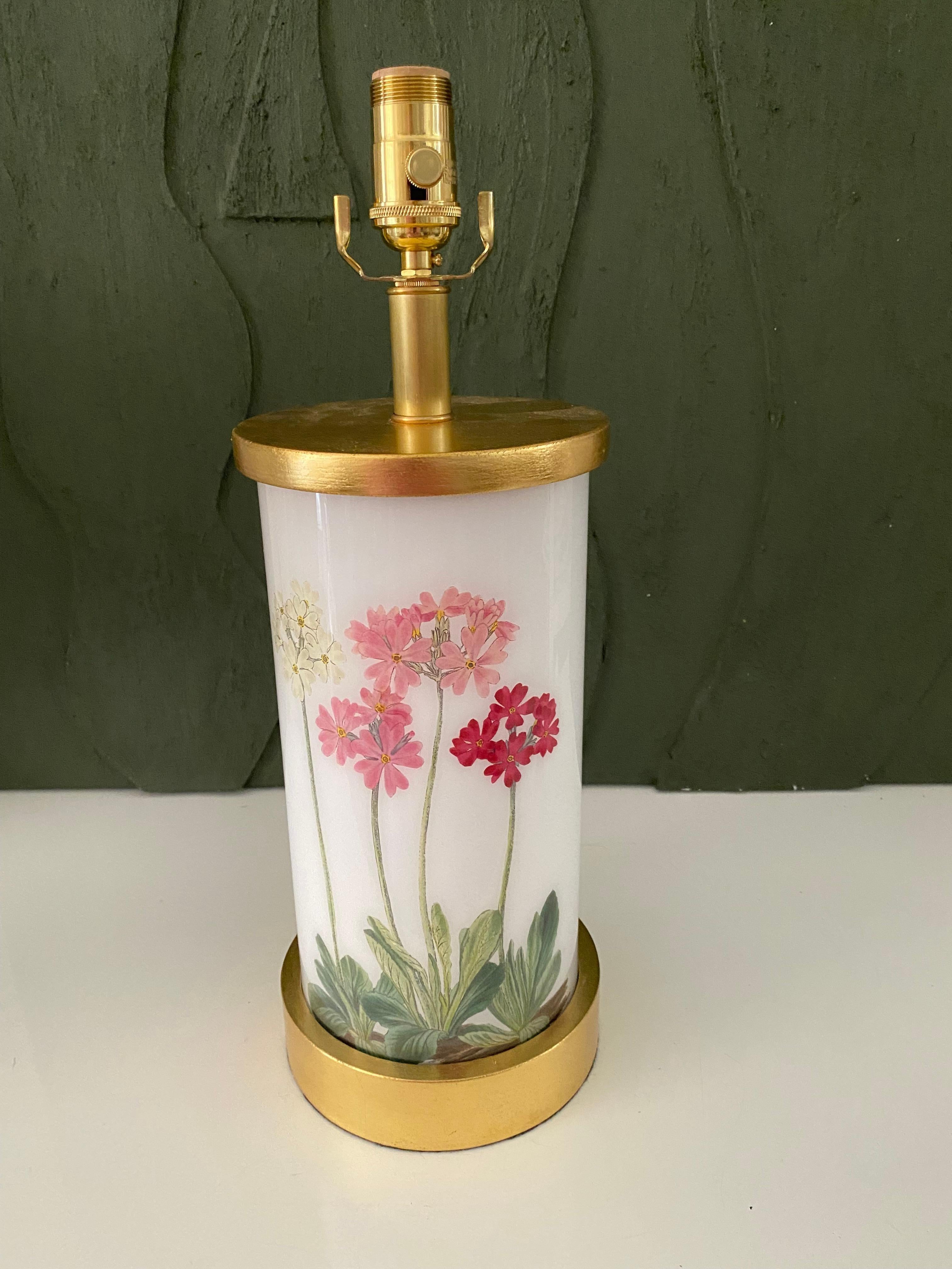Hand made with care in Houston, Texas. This glass lamp features a selection of 19th century hand-colored engravings of beautiful primulas in pink and red hues against a soft white background, with hand-turned gilt wood base and cap, polished brass