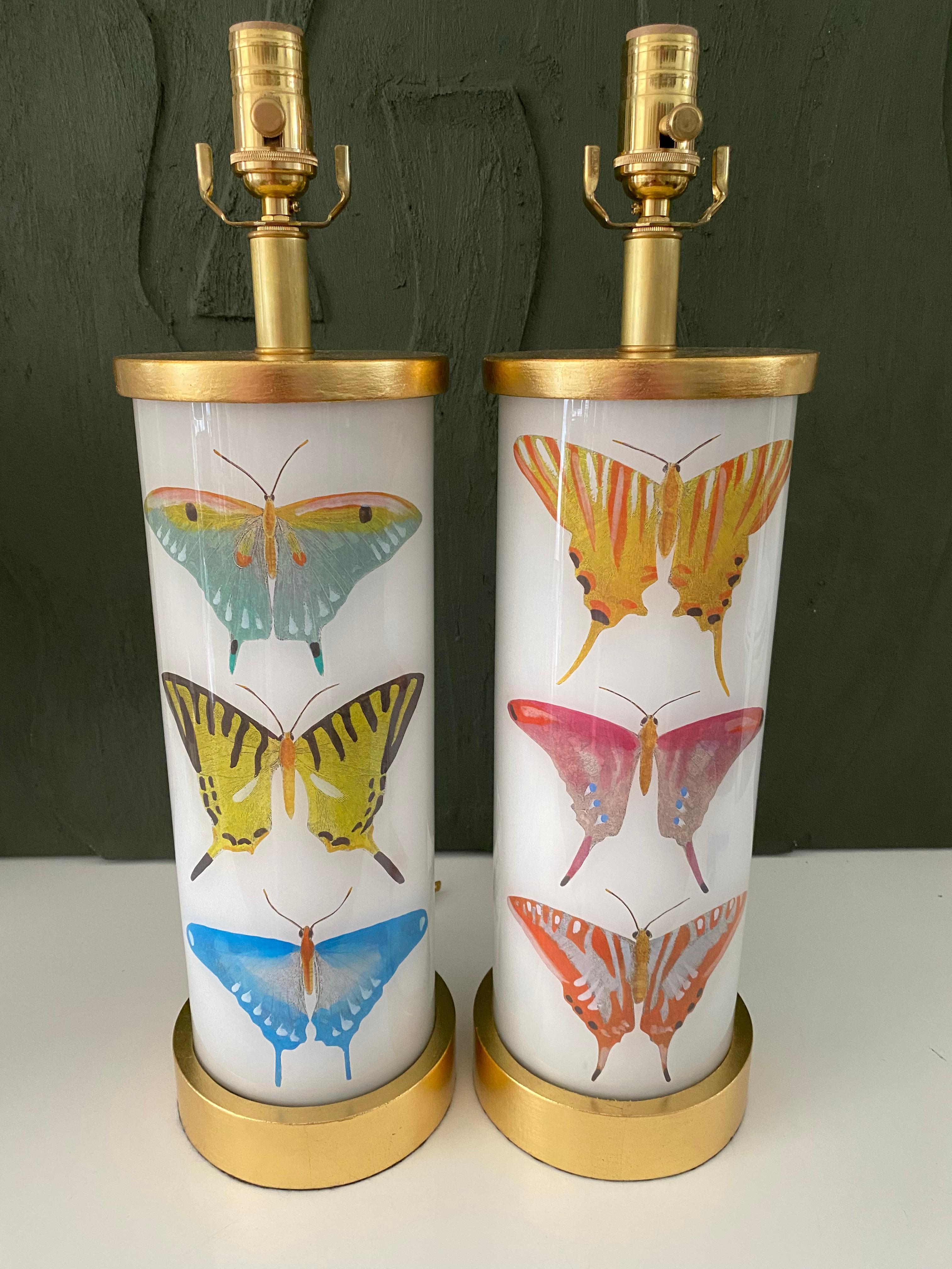 Hand made with care in Houston, Texas. This pair of glass lamps features a selection of 18th century hand-colored engravings of beautiful butterflies, with hand-turned gilt wood base and cap, antique brass dimmer socket and clear cord. All UL listed