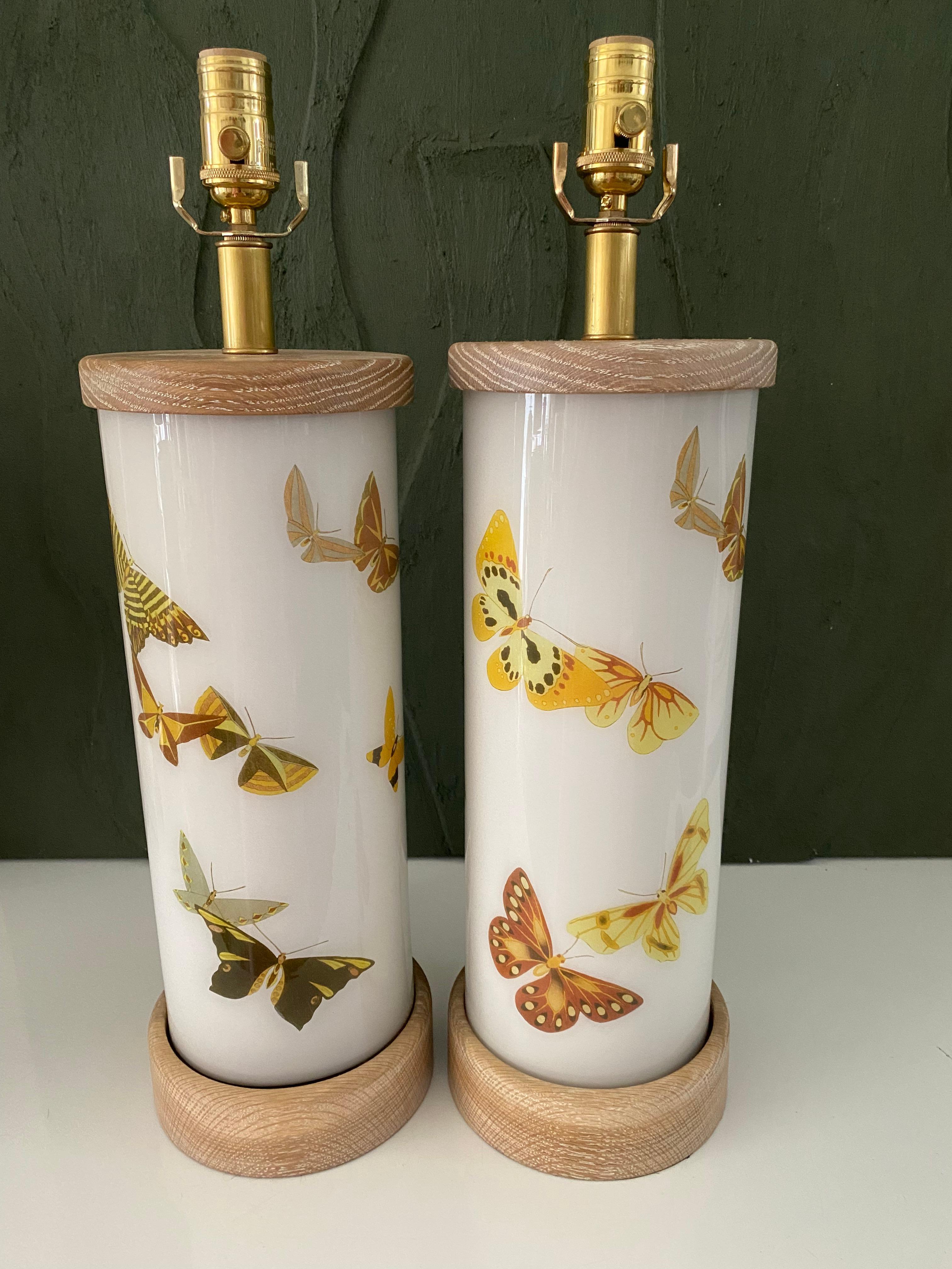 Hand made with care in Houston, Texas. This glass lamp features a selection of earth-tone beautiful butterflies against a soft white background, for a mid-century modern feel. They have hand-turned cerused oak bases and caps, polished brass dimmer