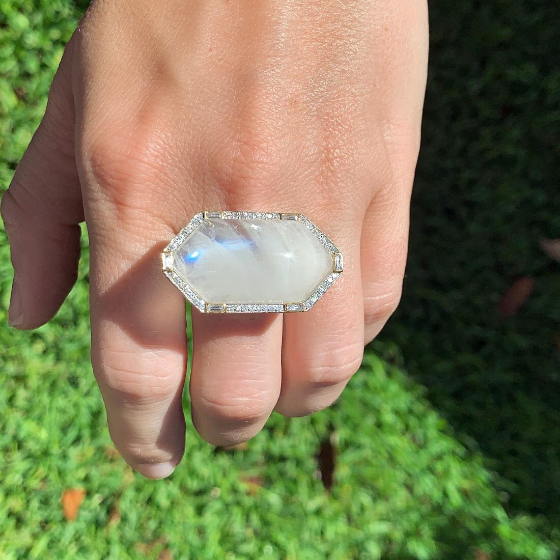 Statement Ring by jewelry designer Liza Beth featuring an oversized, glowing moonstone cabochon surrounded by full-cut diamonds set in satin-finished sterling silver and beautifully accented by six baguette diamonds bezel-set in 14k yellow gold. The