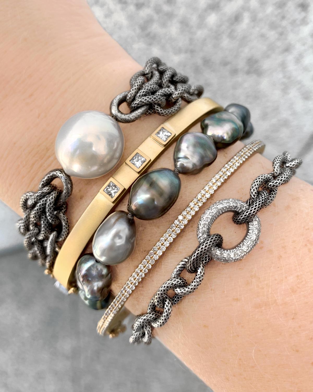 One of a Kind Tahitian Keshi Pearl Links Bracelet featuring fourteen lustrous, iridescent Tahitian keshi pearls and finished with a 14k yellow gold lobster clasp embedded with one round brilliant-cut white diamond. Hallmarked.

About the Designer -