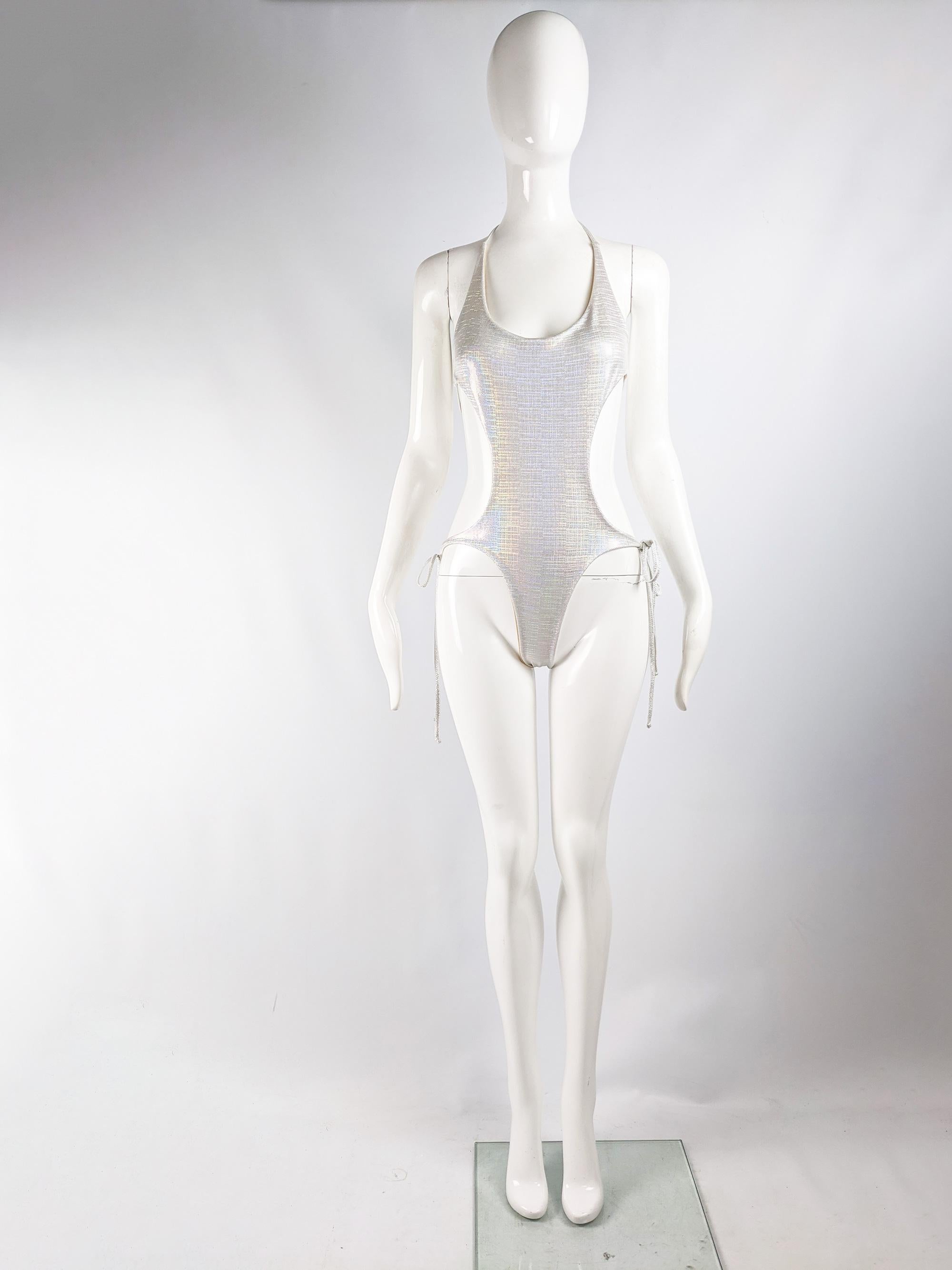 A fabulous vintage womens one piece swimsuit from the 80s by high end swimwear designer, Liza Bruce who designed Kate Moss's iconic 1993 sheer dress. In a silver holographic fabric with 4 sets of straps creating a backless, cut out