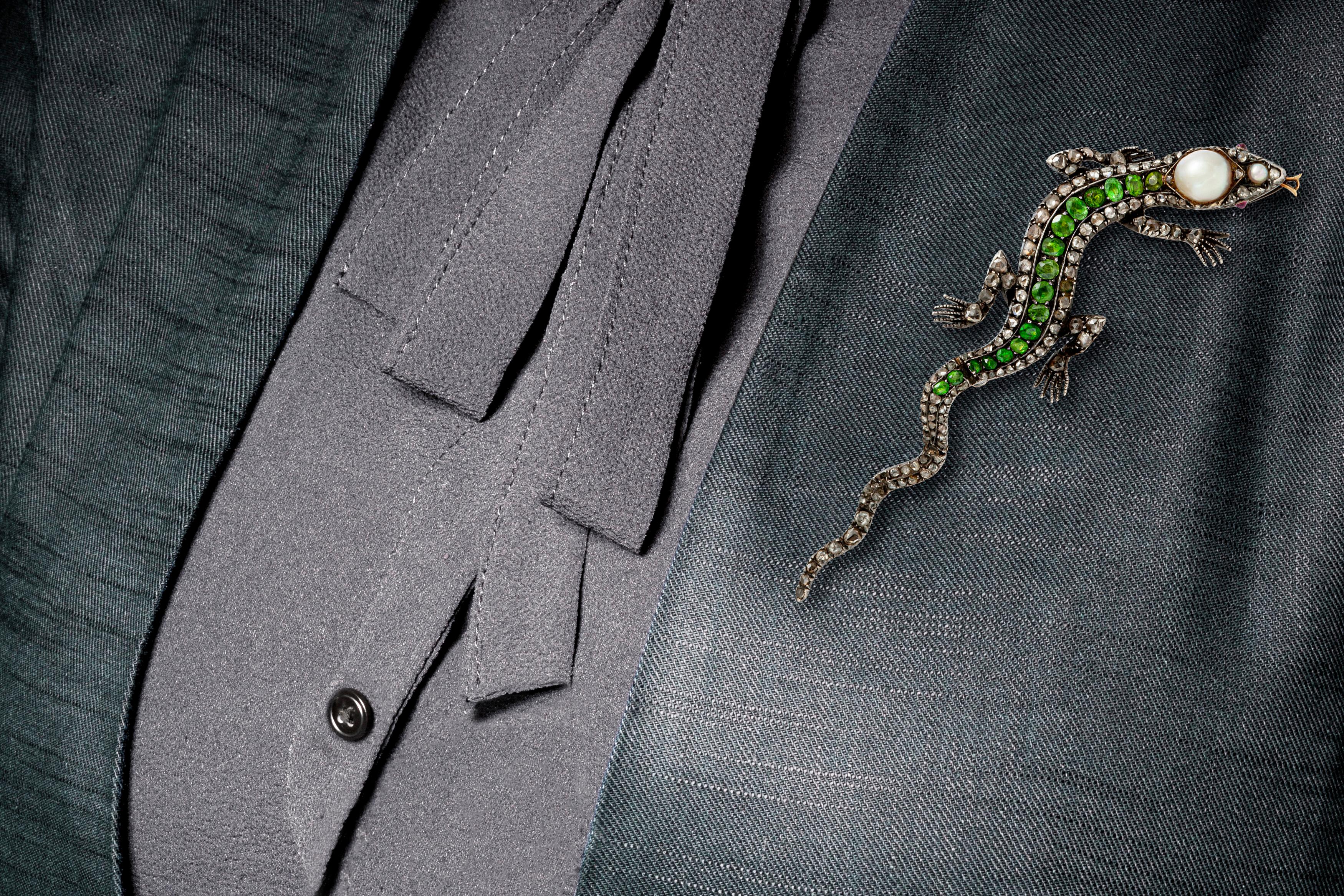 Lizard pin, finely crafted in silver and gold with pearls, tsavorite and diamonds. Circa 1900's.