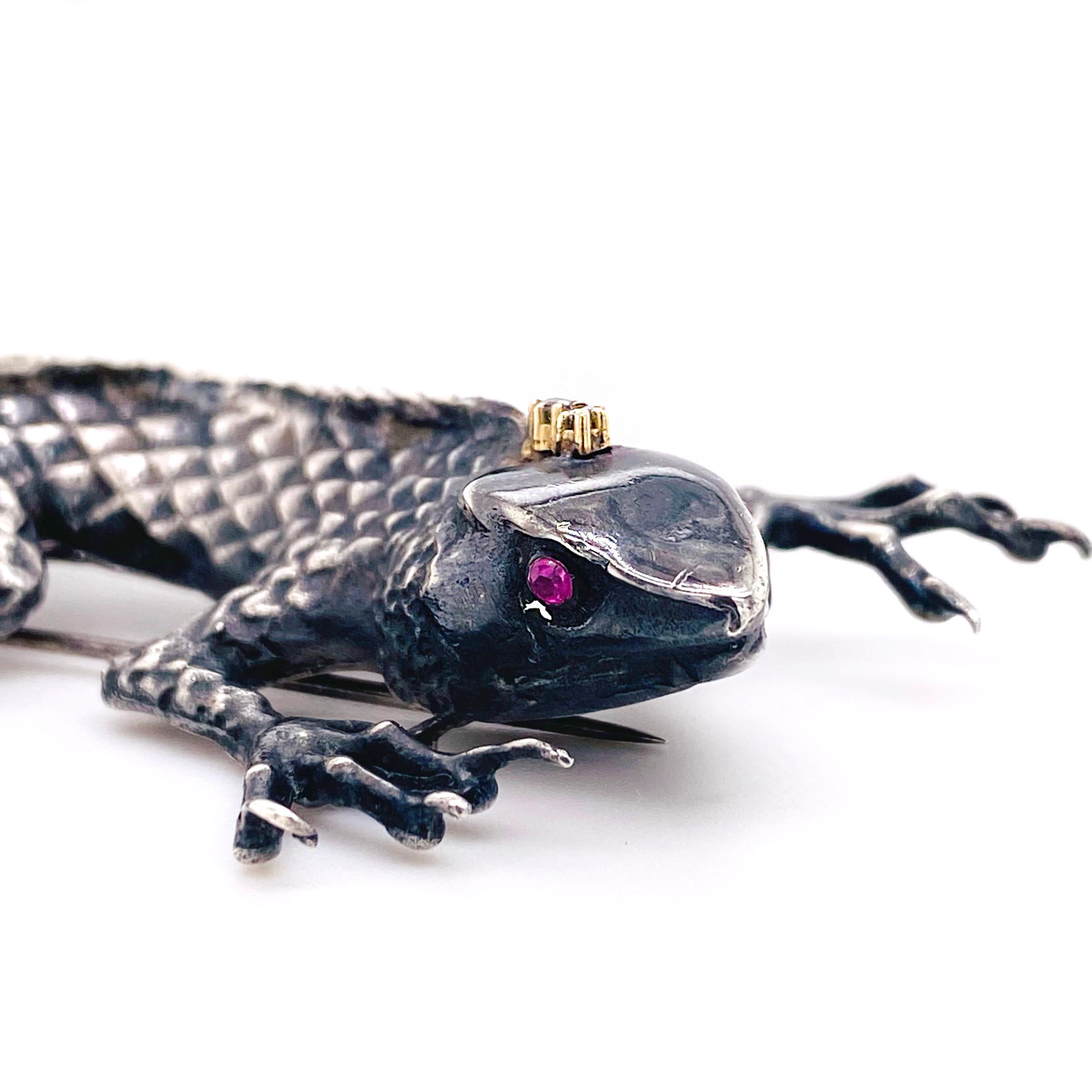 Hand crafted, one-of-a-kind sterling silver lizard. The lizard has a strong glare with rubies in its eyes and diamonds on its head! The brooch is stunning on a scarf or jacket and really is a work of art!
The details of this beautiful brooch is