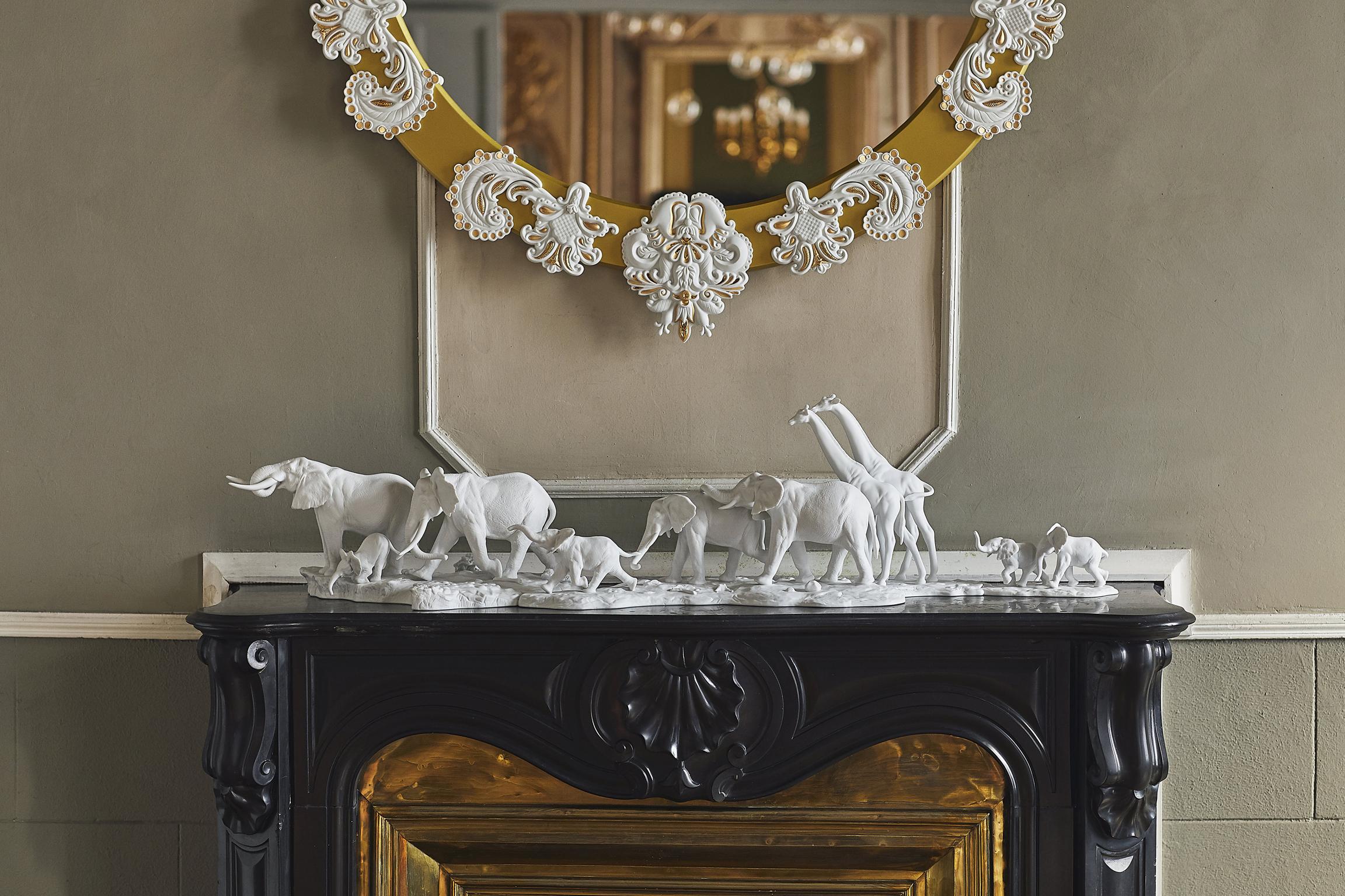 Sculpture in matte white porcelain animals from African savannah, adult female elephant that guides her group through a long path with an iroko wooden base. As an African proverb says: If you want to go fast, go alone. If you want to go far, go in