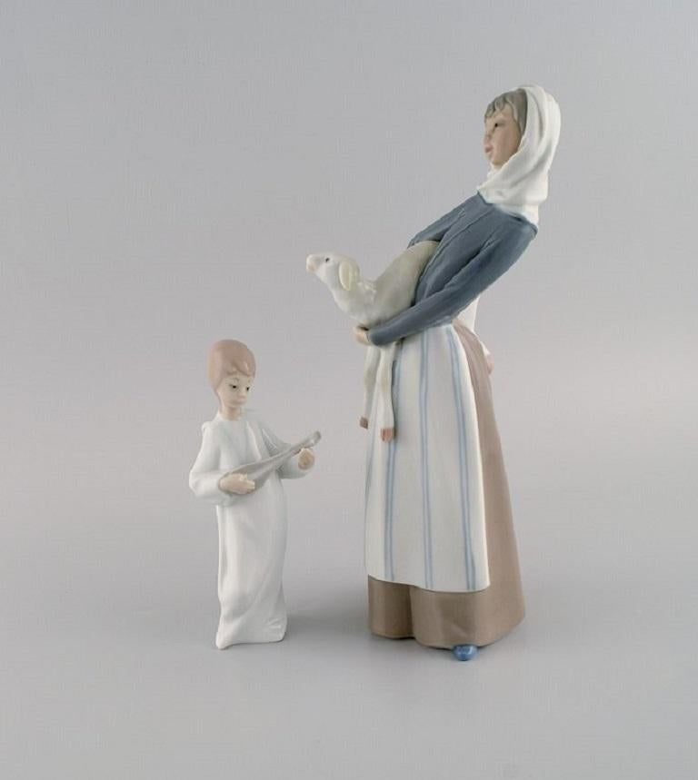 Lladro and Nao, Spain. Two porcelain figurines. 
Girl with lamb and angel boy. 1970s / 80s.
Largest measures: 27.5 x 12 cm.
In excellent condition.
Stamped.