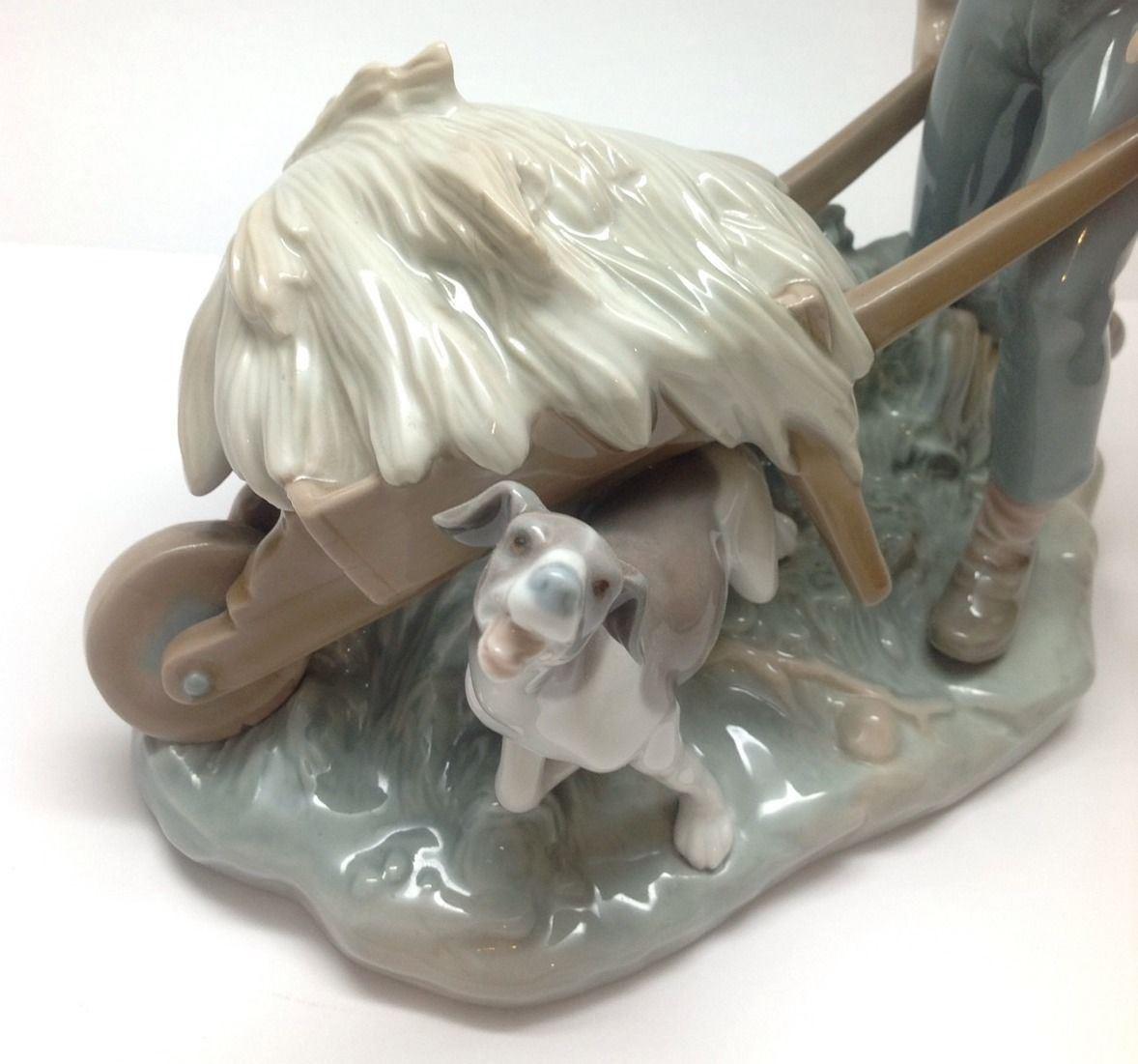 Lladro boy with wheelbarrow and dog porcelain figurine. 
Marked on bottom: LLADRO. 
Stands approx 8