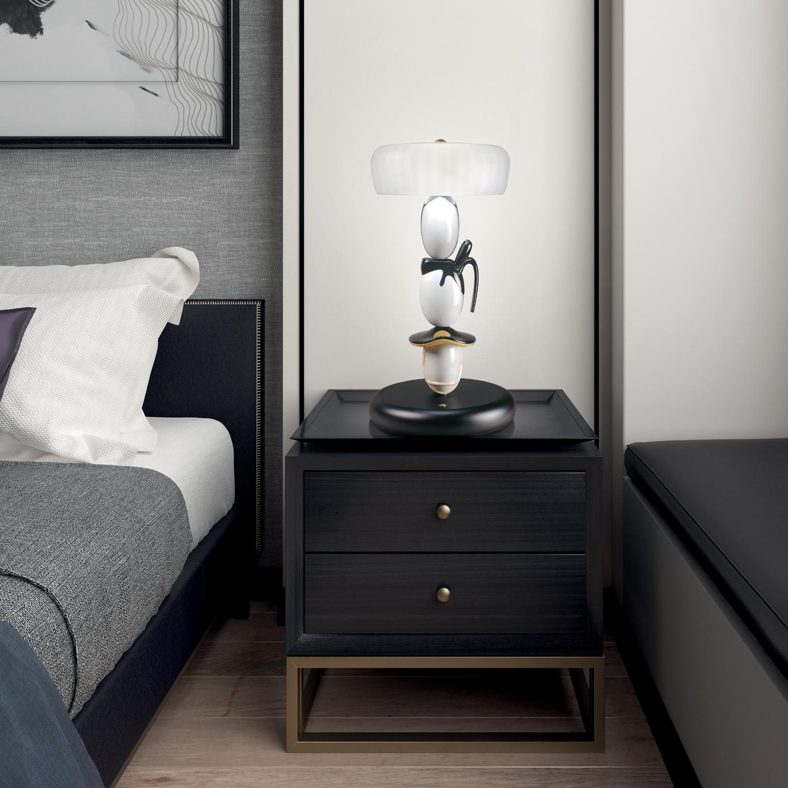 Table lamp in black and white porcelain with touches of gilded sheen, features Murano blown glass screens in several layers that are inspired by the sandogasa hats. The Hairstyle collection of lamps has been conceived by the team of Lladró Atelier,