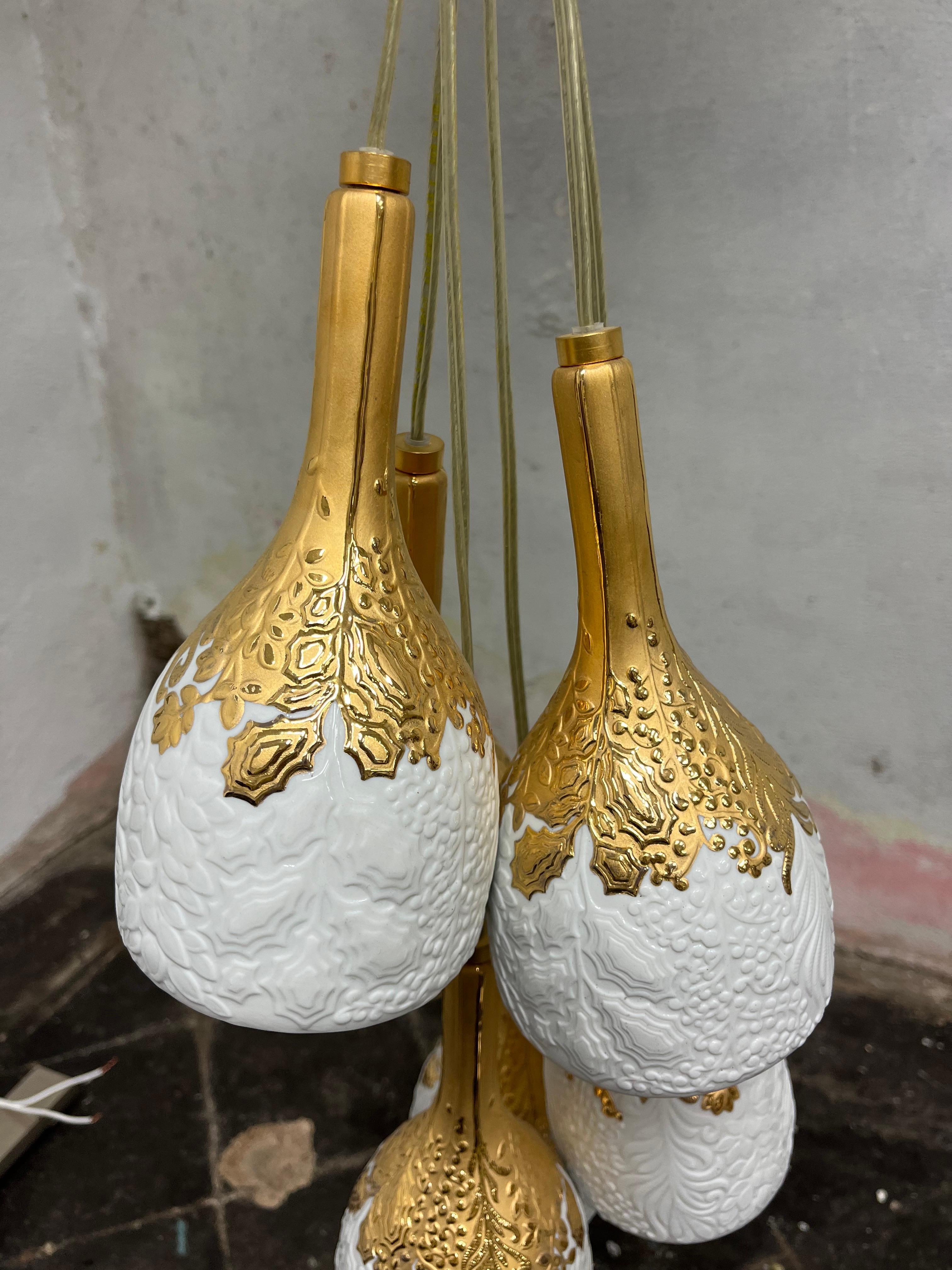 Hängende Deckenlampe aus weißem Porzellan und vergoldetem Glanz, verziert mit handgefertigten Naturmotiven, mit sechs Lichtern.
Ausführung: Weiß und Gold
MATERIAL: Porzellan
Abmessungen: 15,75