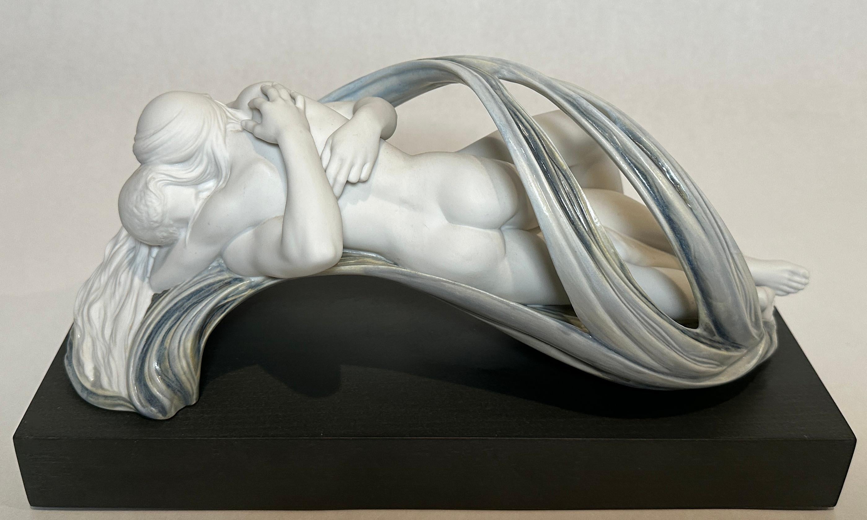 Sculpture en porcelaine de Lladro Amor et Desirerium sculptée par Ernest Massuet pour Lladro. Traduit par Amour et Désir, figurine en porcelaine au fini mat et émaillé.
Deux vies se confondent. Suspendu dans les airs, le couple est entouré de