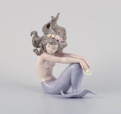 Lladro, Spain, handmade porcelain figurine of a sitting mermaid.