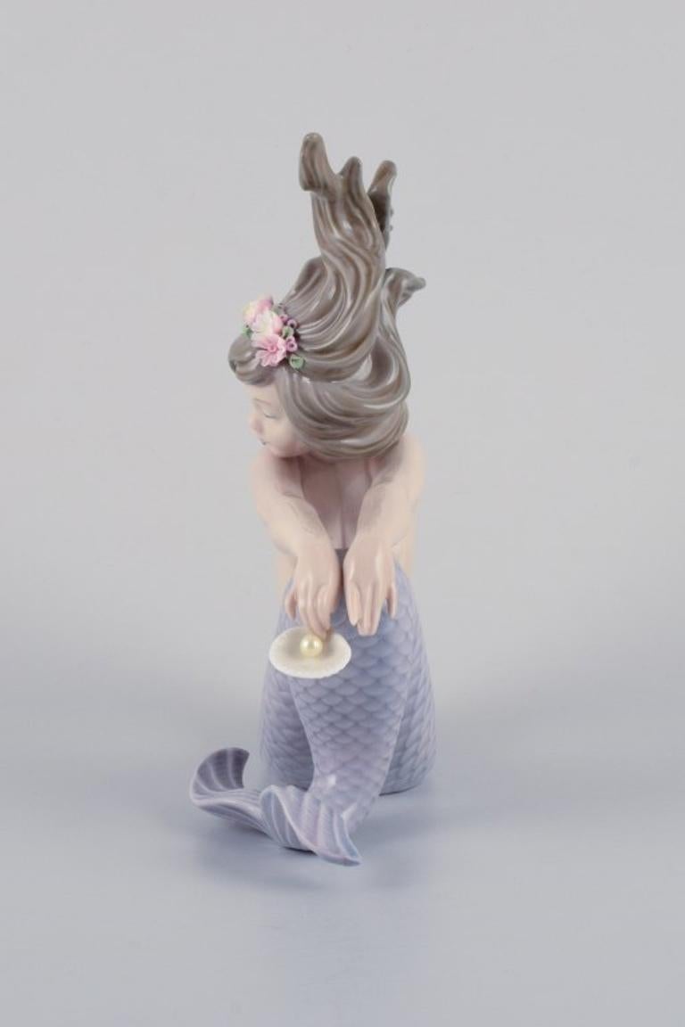 Late 20th Century Lladro, Spain, handmade porcelain figurine of a sitting mermaid.