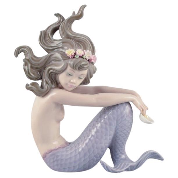 Lladro, Spain, handmade porcelain figurine of a sitting mermaid.