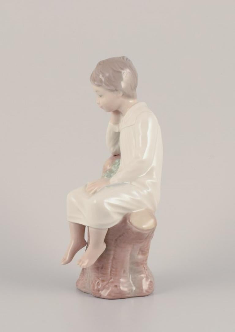 Spanish Lladro, Spain. Porcelain figurine of a girl sitting on a tree stump.  For Sale