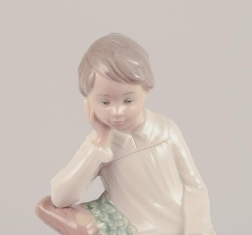 Glazed Lladro, Spain. Porcelain figurine of a girl sitting on a tree stump.  For Sale