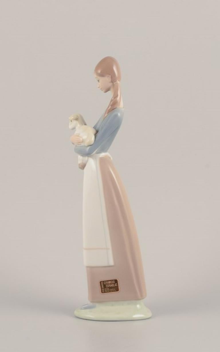 Lladro, Spanien. Porzellanfigur einer stehenden jungen Frau, die ein Lamm in den Armen hält.
Ungefähr in den 1980er Jahren.
Markiert.
Perfekter Zustand.
Abmessungen: Höhe 26,6 cm x Durchmesser 8,0 cm.