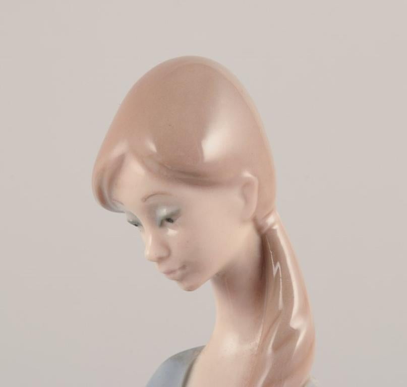 Lladro, Spanien. Porzellanfigur einer stehenden jungen Frau, die ein Lamm hält. (Glasiert) im Angebot