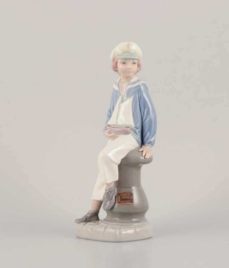 Lladro, Spanien. Porzellanfiguren aus Porzellan. 
Junge im Matrosenoutfit mit einem Modellschiff in der Hand und einer Mädchenfigur.
Ungefähr in den 1980er Jahren.
Markiert.
Perfekter Zustand.
Aufkleber.
Junge: Höhe 22,5 cm x Breite 9,5 cm.