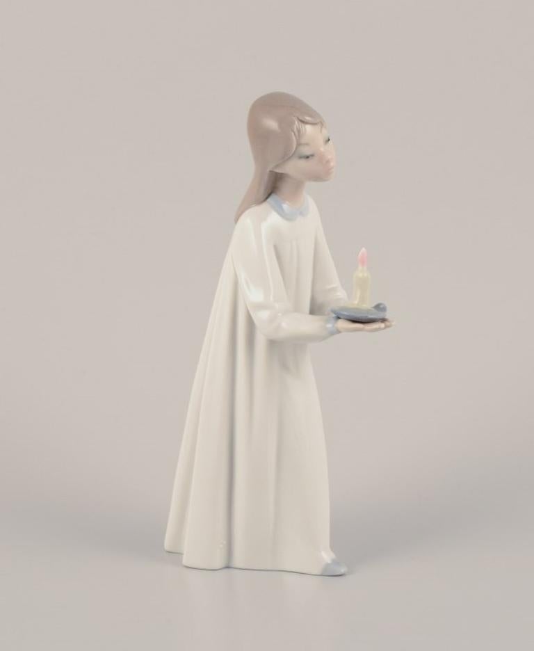 Lladro, Spain. Two porcelain figurines. 
Girl with a nightstand lamp and an angel figurine with a sleeping child.
Approximately from the 1980s.
Marked.
Perfect condition.
Sticker.
Girl with lamp: Height 20.0 cm x Width 10.0 cm.