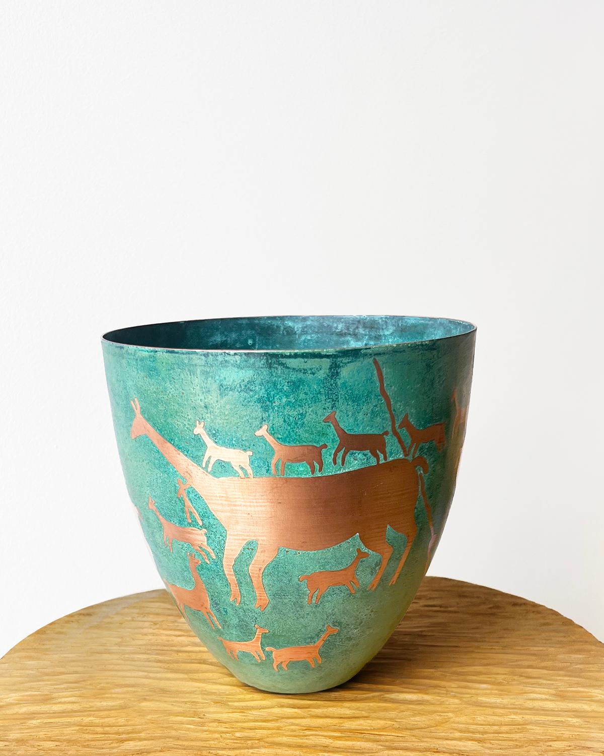An etched copper vessel with green patina
This Llama Caravan Etched Copper Vessel is a wonderfully unique home accent. The intricate etching of llamas on its copper surface is enhanced with a verdigris green patina. The style is reminiscent of