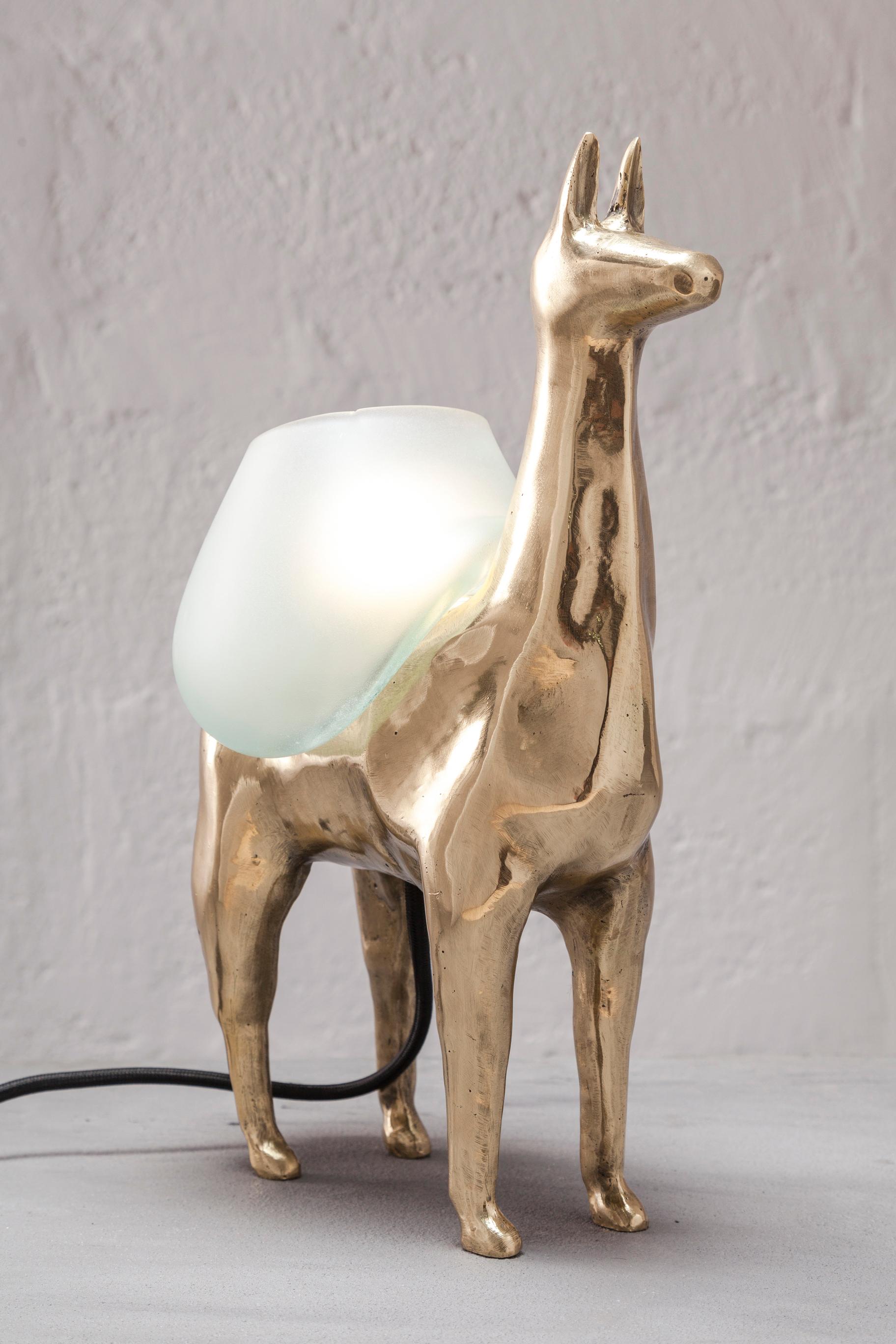 LLAMA is a table lamp, composed of a lost-wax cast bronze body, and a handblown glass lampshade. It is a reinterpretation of an archetype of llama sculptures essential within Ecuadorian artisanship. The form was hand-sculpted in ceramic, then 3D