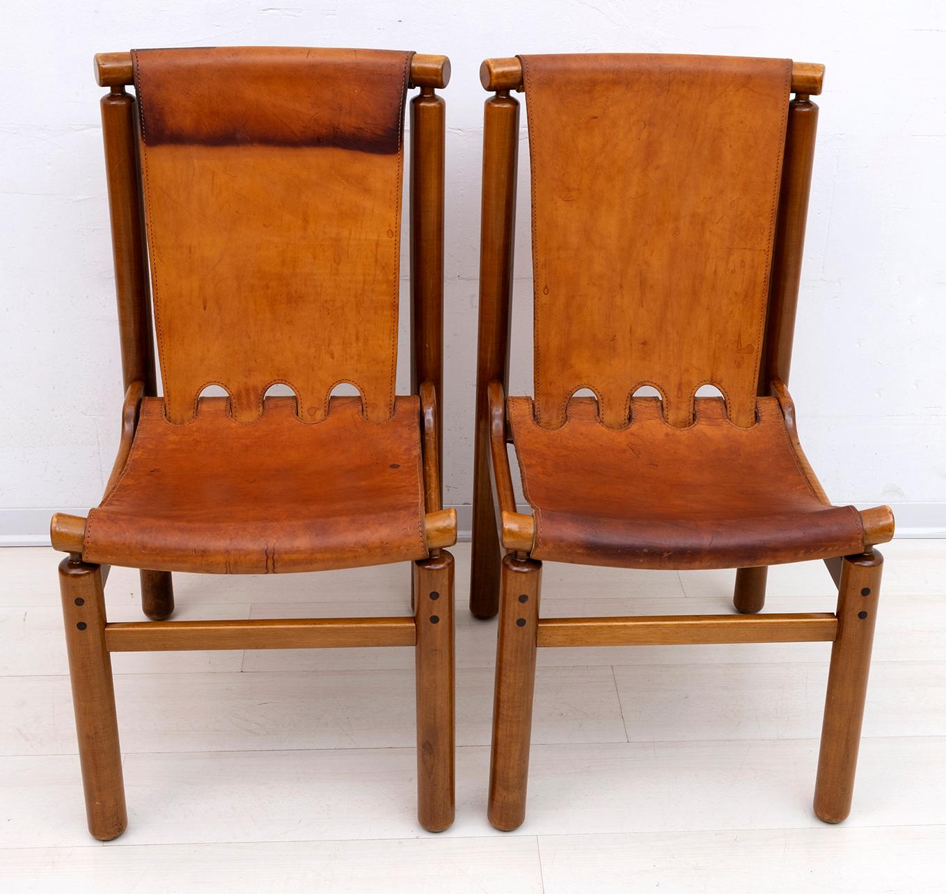Ilmari Tapiovaara for La Permanente Mobili Cantù, light walnut stained beech and patinated cognac leather, 1950s. These sturdy chairs by Ilmari Tapiovaara have a geometric structure for the seat and back in patinated cognac leather. In addition to