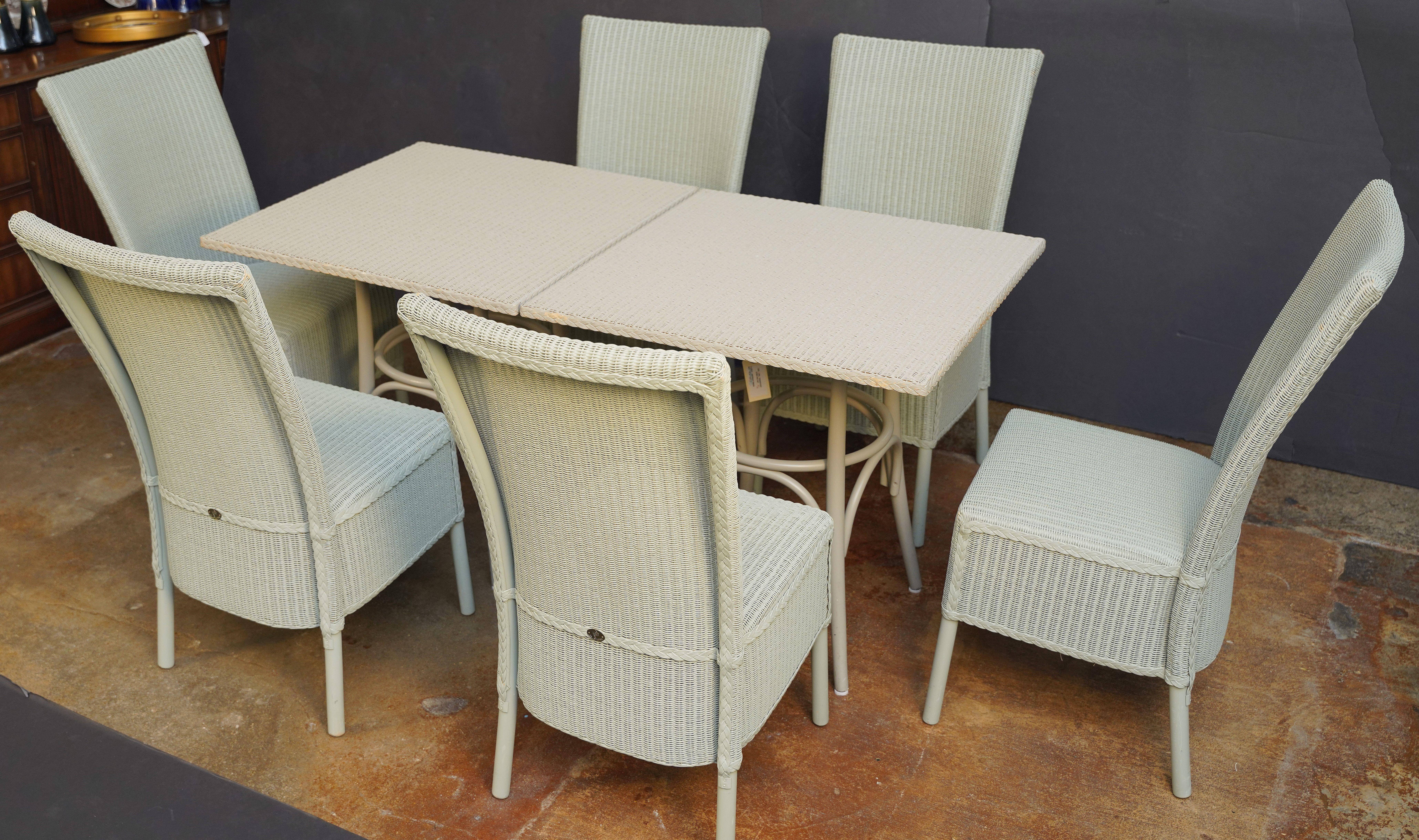 A fine Lloyd Loom table and chairs set - of painted woven wicker and wire - synonymous with Classic English style, featuring six chairs and two tables.

Each chair, featuring an arched back of painted woven wicker and wire over a wood frame, with a