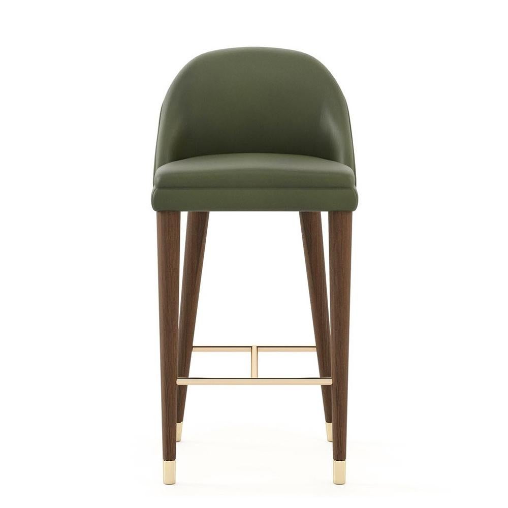 Bar Stool Loanne with wooden feet in walnut matte finish and with
polished stainless steel footrests in gold finish, feet at the bottom
of the legs in polished stainless steel in gold finish. Upholstered
and covered with green genuine