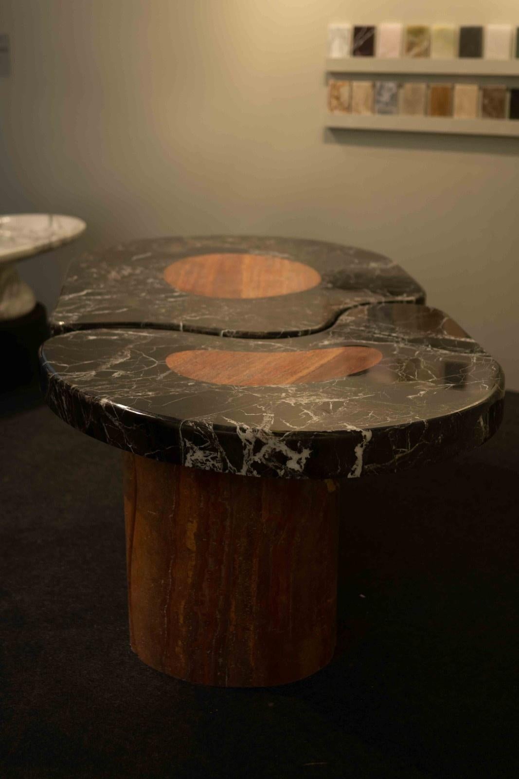 La Mesa de Comedor L'Oasis es una cautivadora fusión de mármol travertino y mármol negro Levanto, que encarna una sofisticada elegancia orgánica. Su diseño esculpido muestra las curvas suaves y fluidas del travertino rojo, que se entrelazan a la