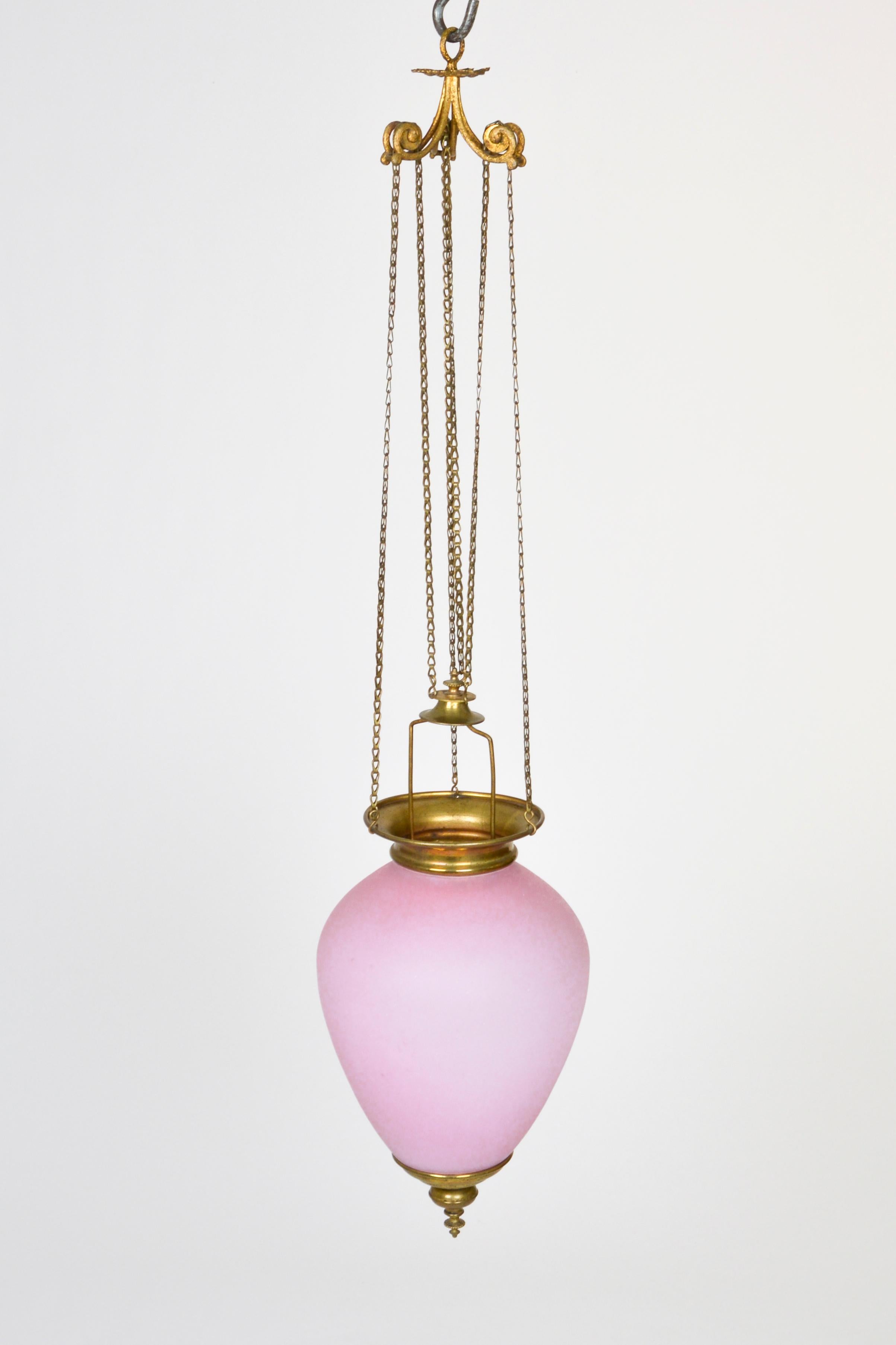 An elegant Biedermeier pendant of a pink milk glass vase. It is set in a pressed brass mounting and suspended from a functioning chain pulley mechanism.
Still in its original condition it is not electrified. It was made for a candle or individual