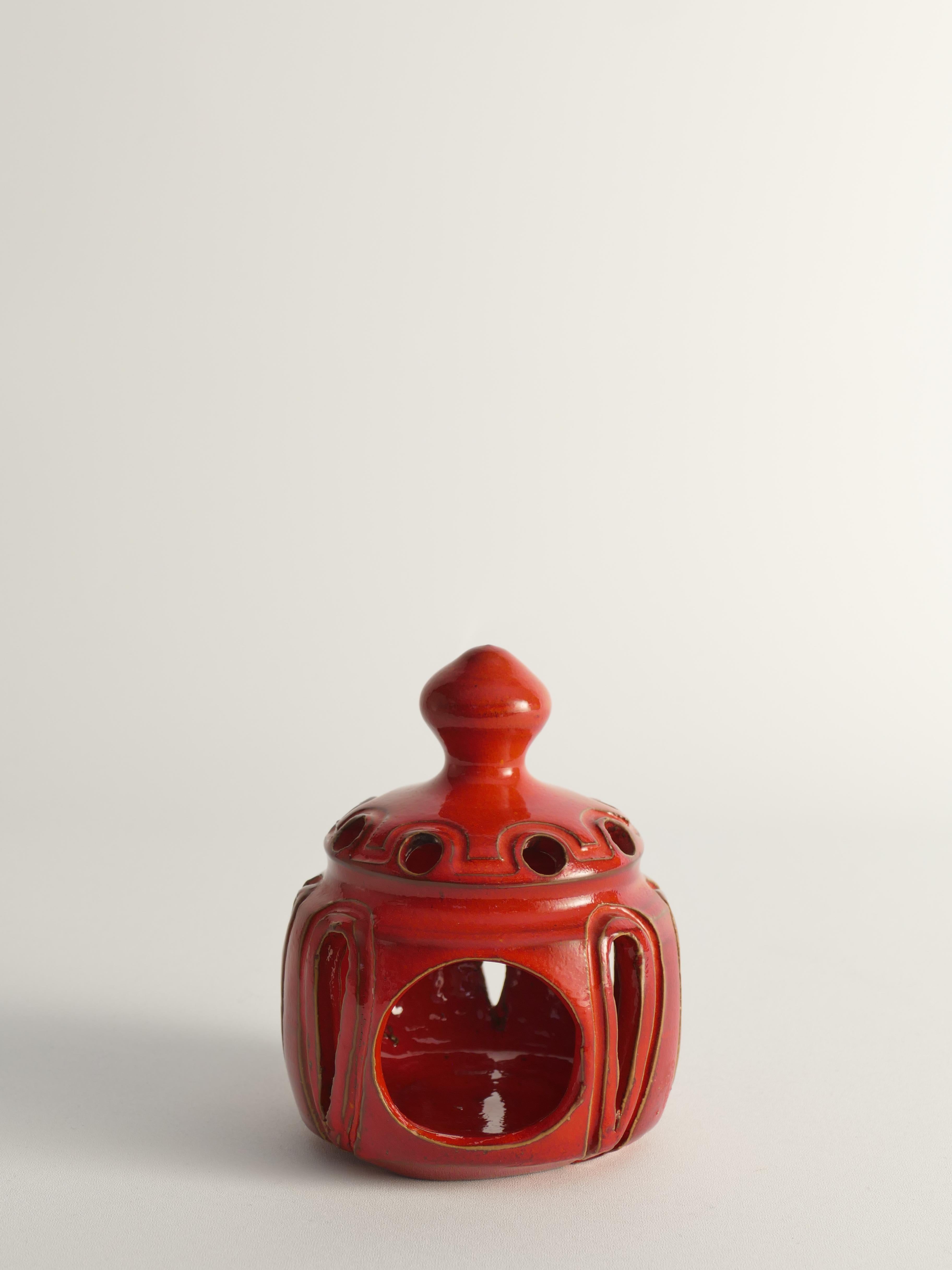 Questo portacandele in terracotta, realizzato a mano da Barbro Sundelin per Basun, in Svezia, negli anni '90, presenta un sorprendente smalto rosso aragosta. Il suo design organico comprende una parte superiore a forma di palla, un'apertura