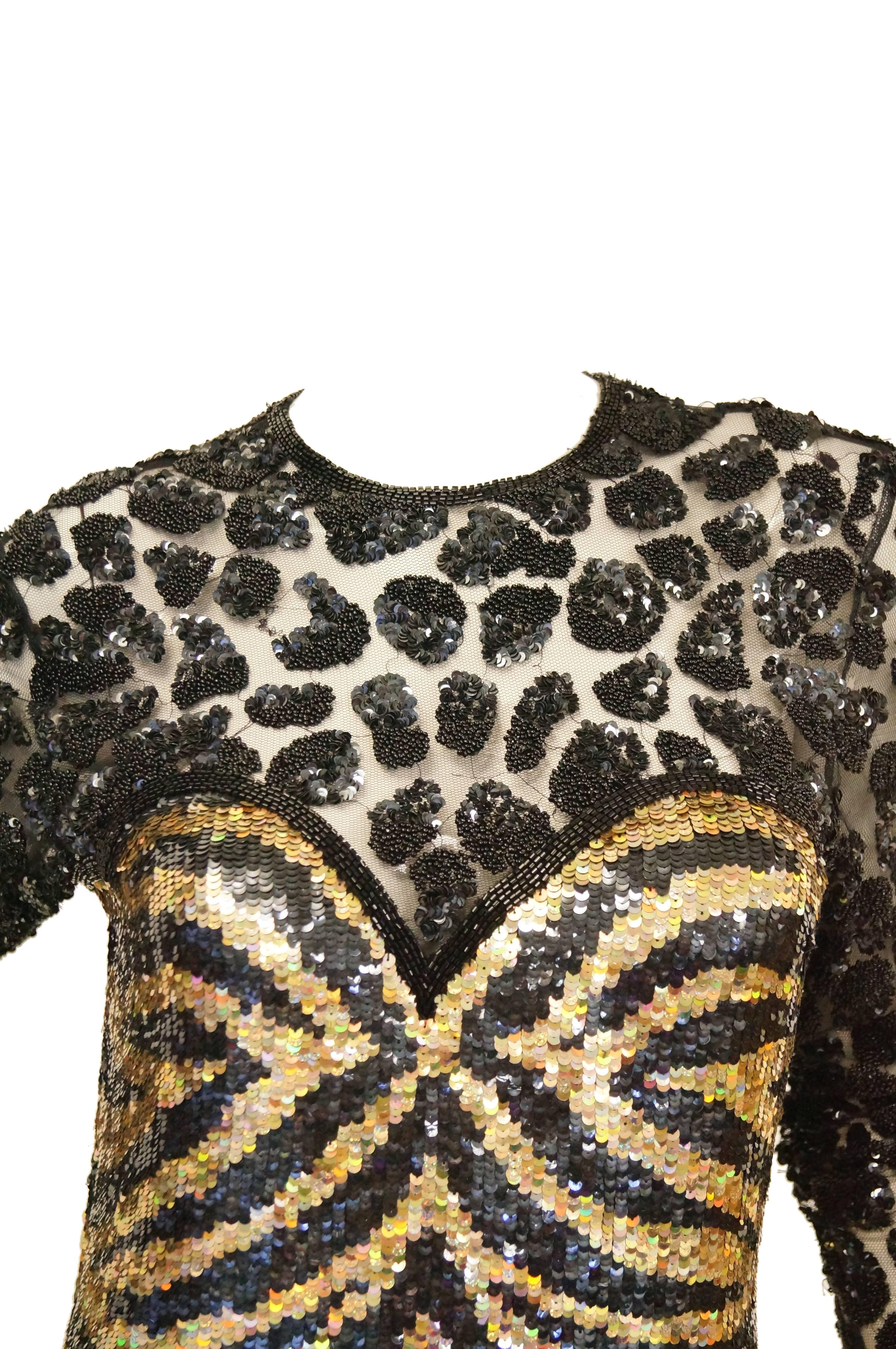 Outrageous Naeem Khan Riazee tiger and cheetah cocktail dress. The dress is form fitting, with a sequin tiger body and sweetheart illusion neckline. The illusion neckline is composed of sheer fabric accented by black cheetah spots. The tiger stripes