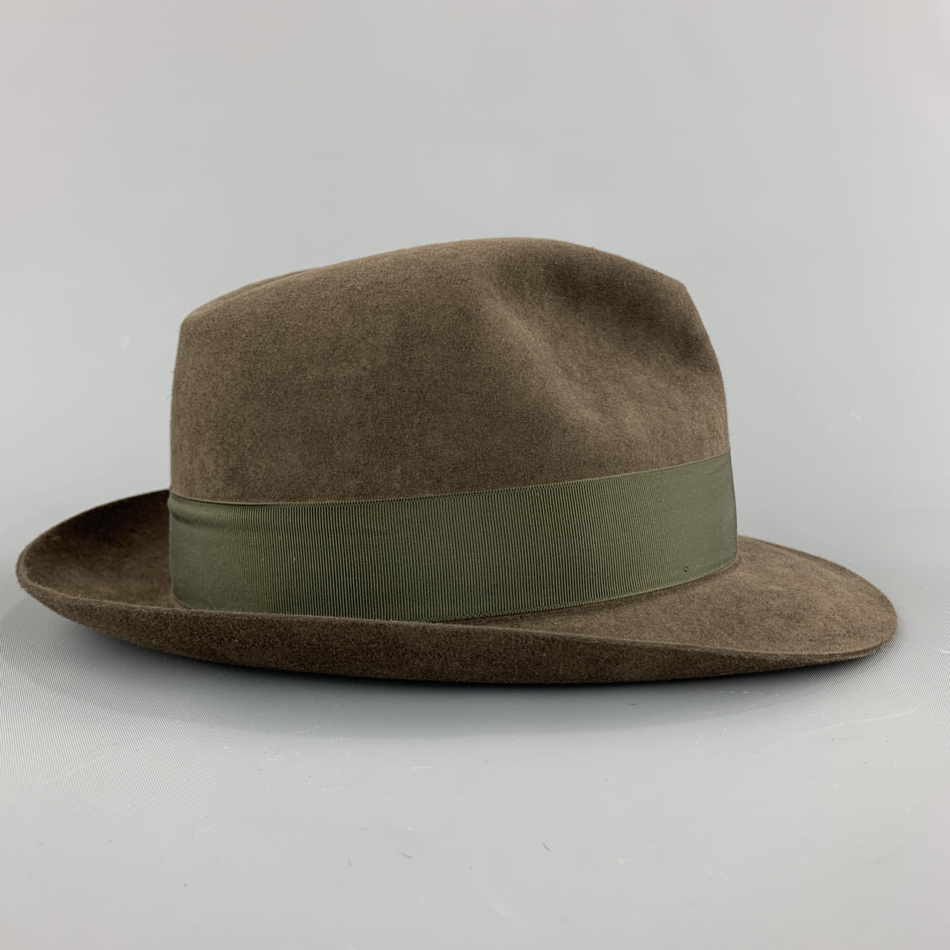 LOCK & CO HATTERS fedora comes in olive green fine fur felt with a thick grosgrain ribbon bow trim. Hand Made in England.

Excellent Pre-Owned Condition.
Marked: 7 1/8 85

Measurements:

Opening: 23.75 in.
Brim:2 in.
Height: 5 in.
