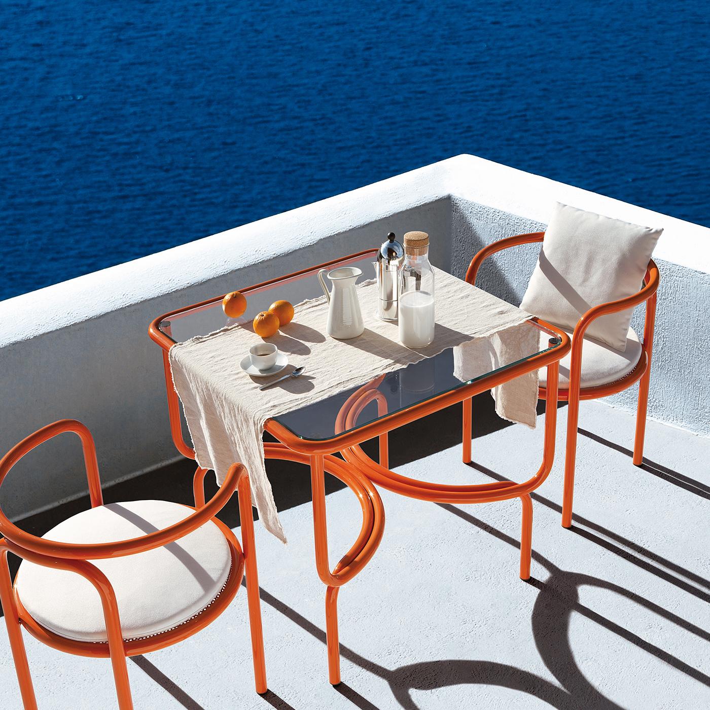 This dining table is an original design from the Locus Solus series of outdoor furniture designed by Gae Aulenti in 1964, brought back by Exteta in 2016. The linear frame of tubular steel is enriched by unexpected curves along the base that recall