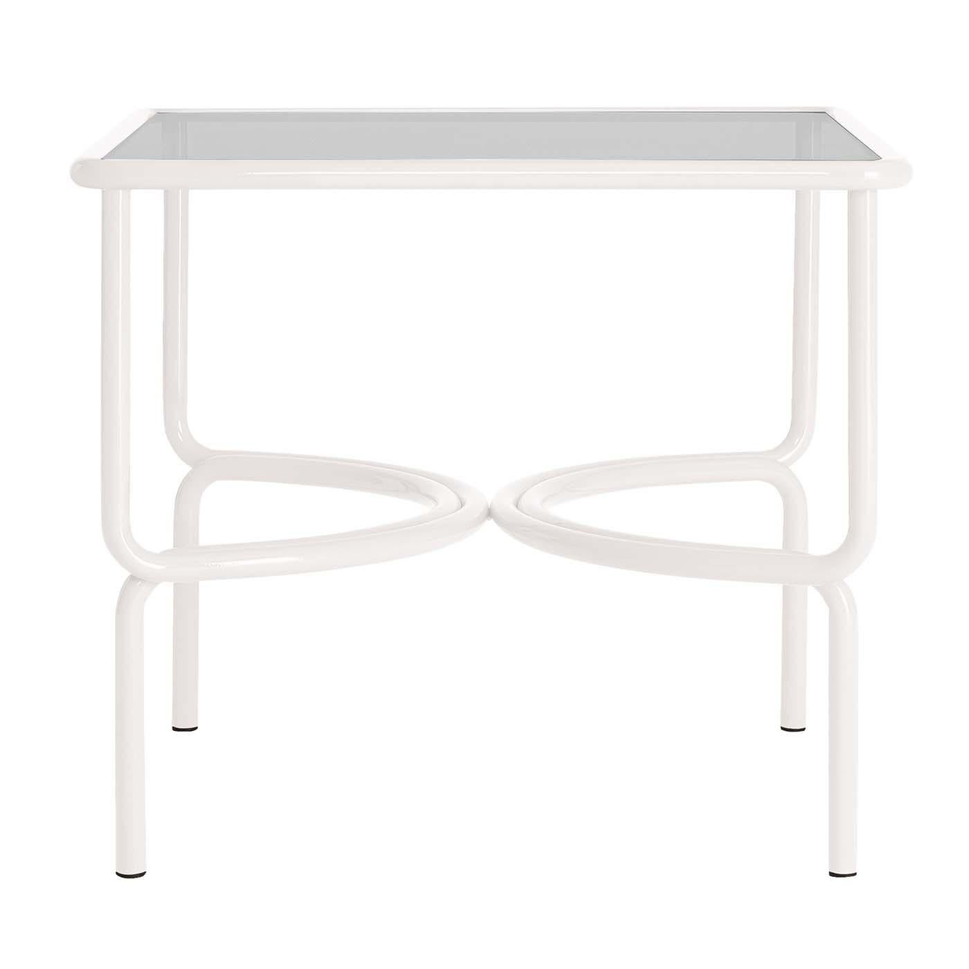 Perfectly integrating with any outdoor setting, this dining table is characterized by a sturdy yet lightweight frame made of white-finished tubular steel. Supporting a square top in extra-light tempered glass, the legs curve inwards at mid-height to