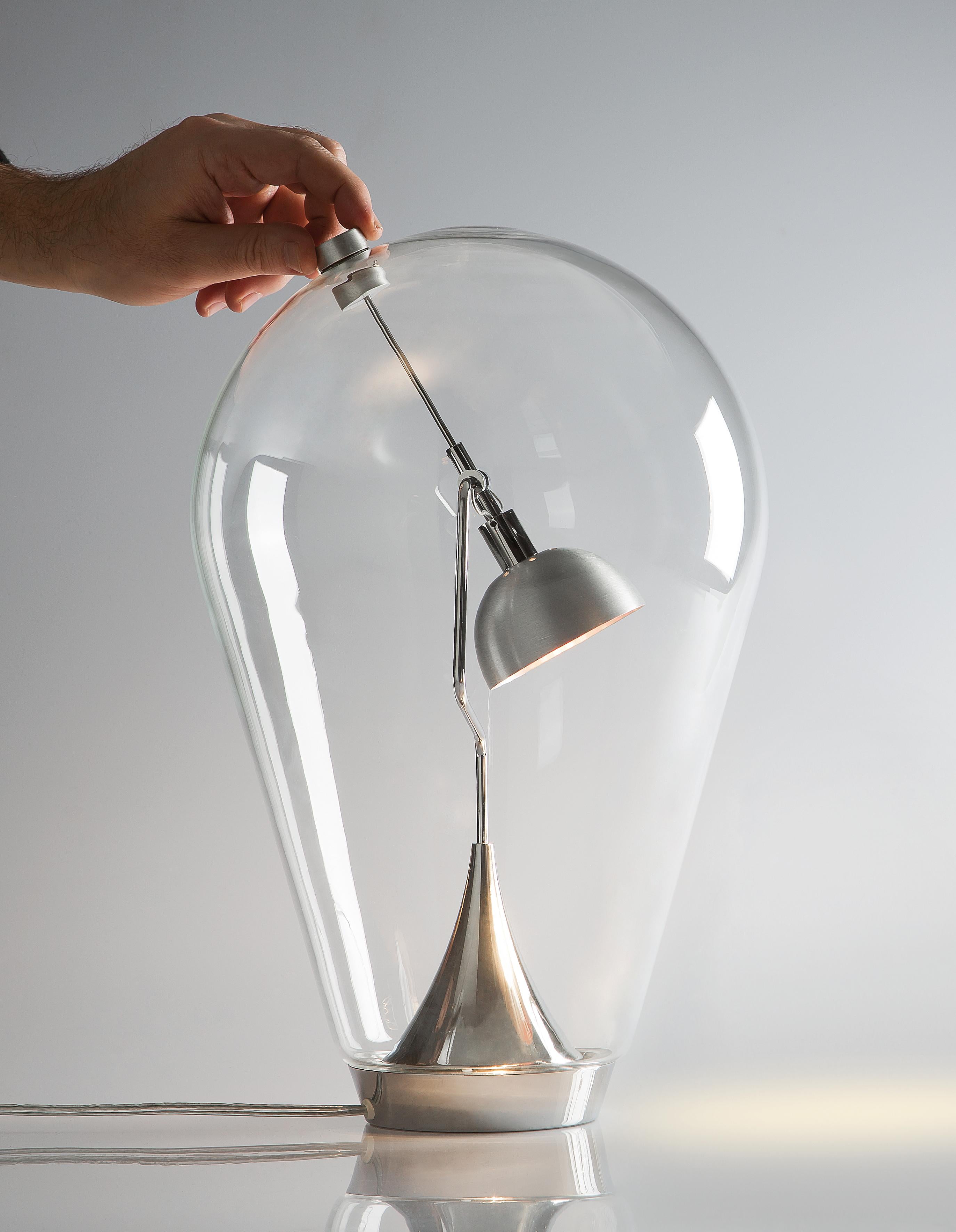 As light as a breath, Blow is an ethereal and original table lamp. Made from blown glass, it contains a bright LED module that can be directed inside the diffuser to create ever-different beams of light. Perfect for reading or furnishing personal