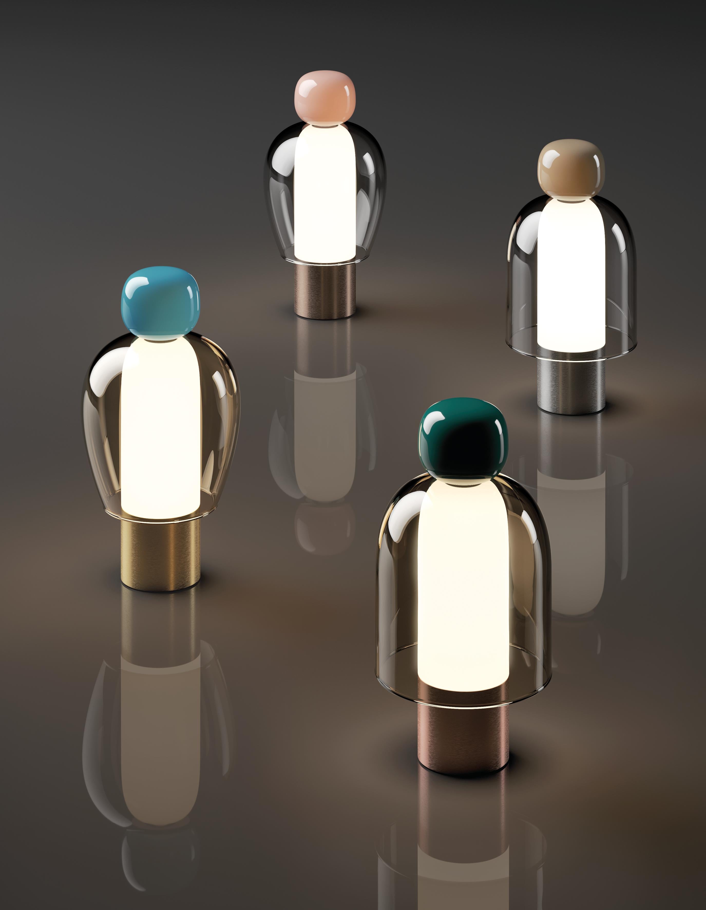 With a strong personality and a sculptural form reminiscing the shape of bells, Easy Peasy is a set of portable and rechargeable table lamps, consisting of two rounded elements, a body and a knob. Made of blown glass, Easy Peasy allows for personal