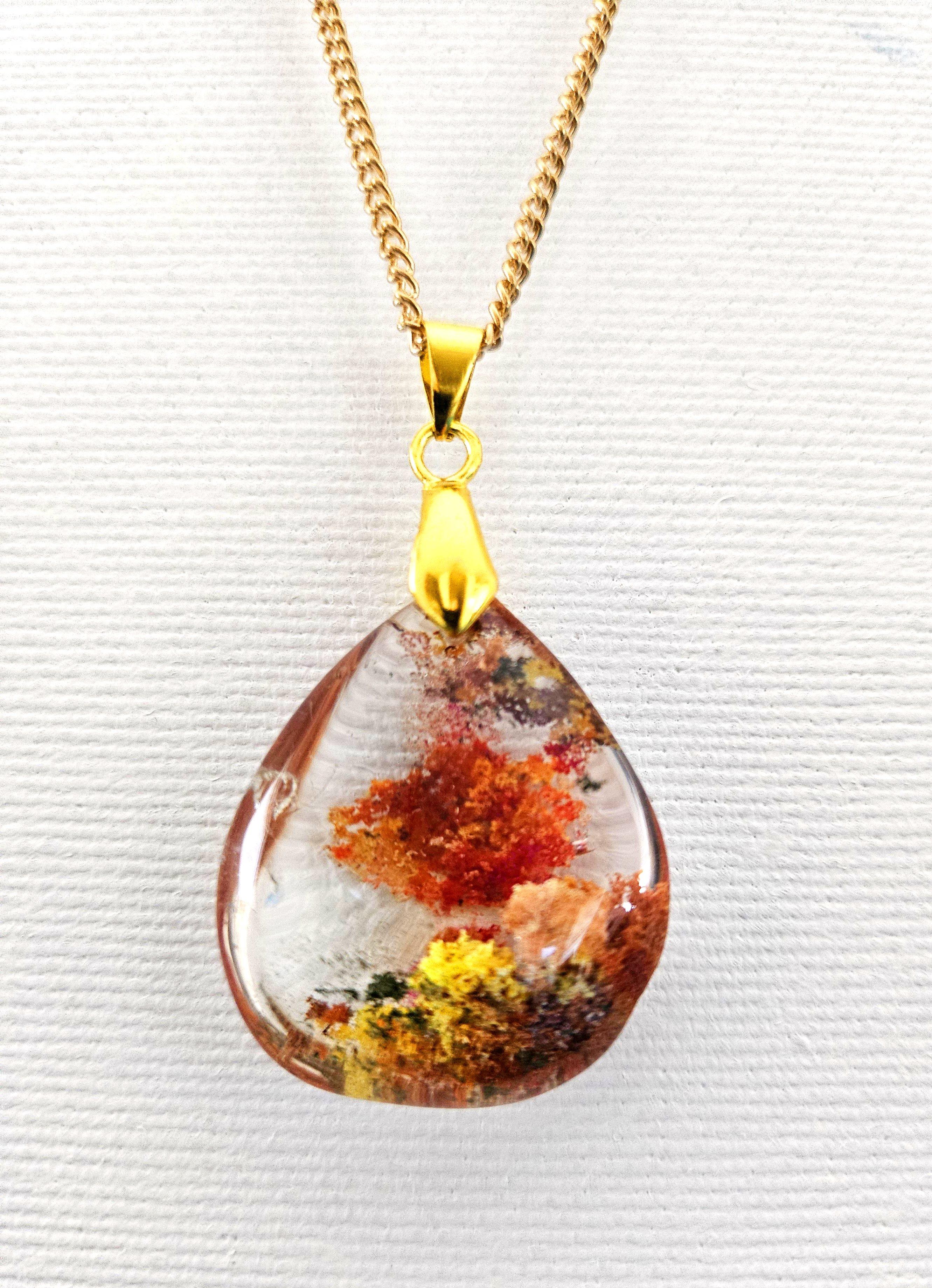 Collier à pendentifs en cristal de Lodolite / Quartz de jardin, rouge, orange, jaune, vert
Voici un joli pendentif en cristal de quartz poli, clair avec un intérieur central en quartz lodolite de style jardin. Les inclusions rouges sont placées vers
