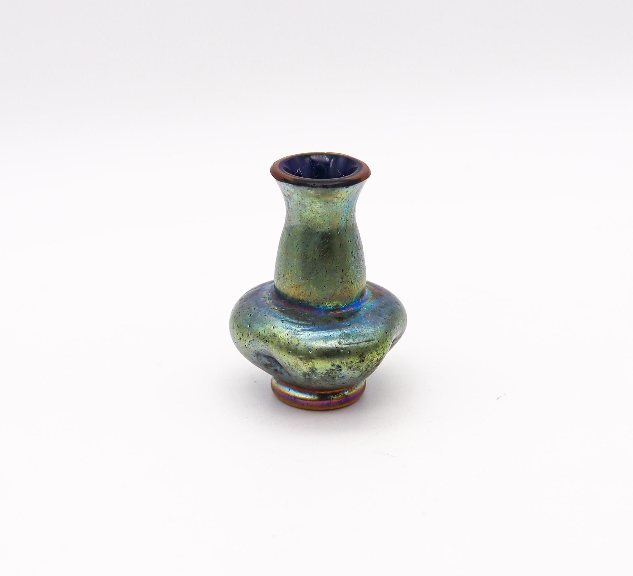 Miniature glass vase designed by Loetz.

Gorgeous and very beautiful antique miniature cabinet glass vase, created by Loetz. Made in Bohemia, Austria during the art nouveau period, back in the turn of the 20th century, circa 1900. Crafted with a
