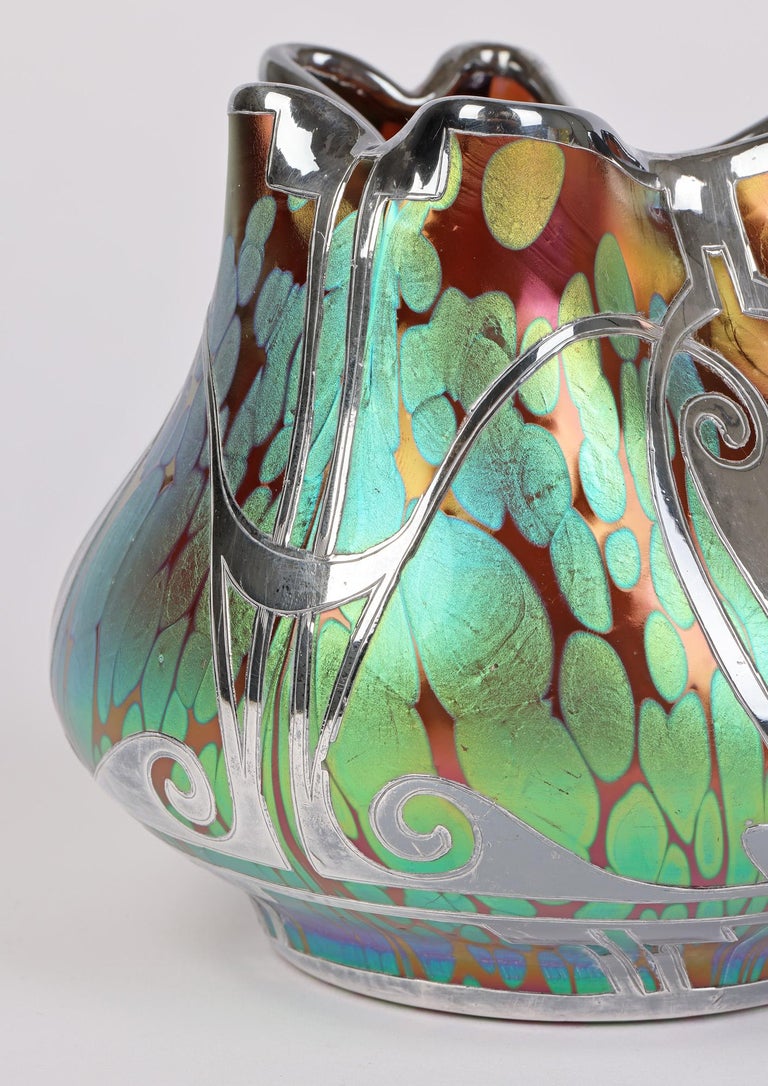 An exceptional and rare Bohemian art nouveau Phaenomen pattern silver overlaid Loetz bud shaped vase dating from around 1902. This beautiful vase stands raised on a narrow rounded spread foot and is of squat wide round shape with a with a pinched