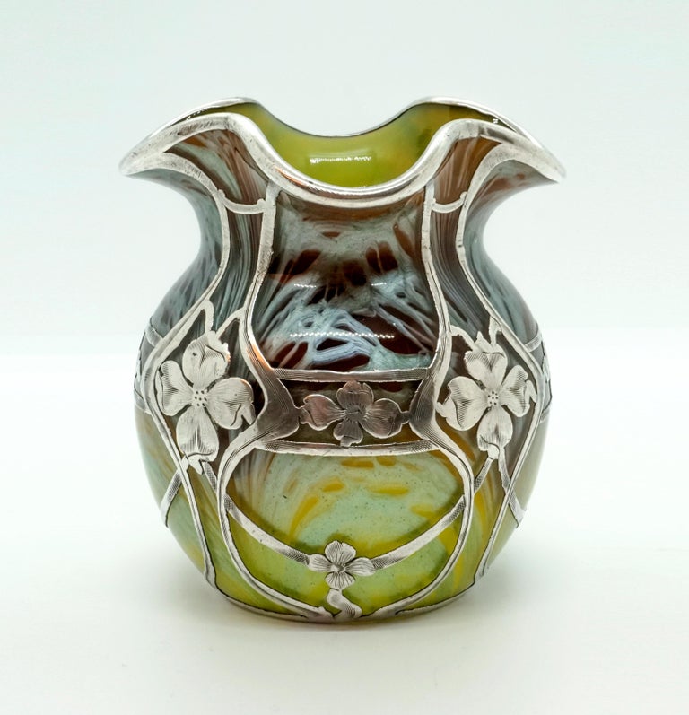 Finest Bohemian Art Nouveau glass vase

Blown glass, bulbous body with a short, wide neck, mouthpiece shaped as a quatrefoil; with floral silver plating and silver coated lip rim. Based on a round, slightly hollowed floor plan.

Shape:
