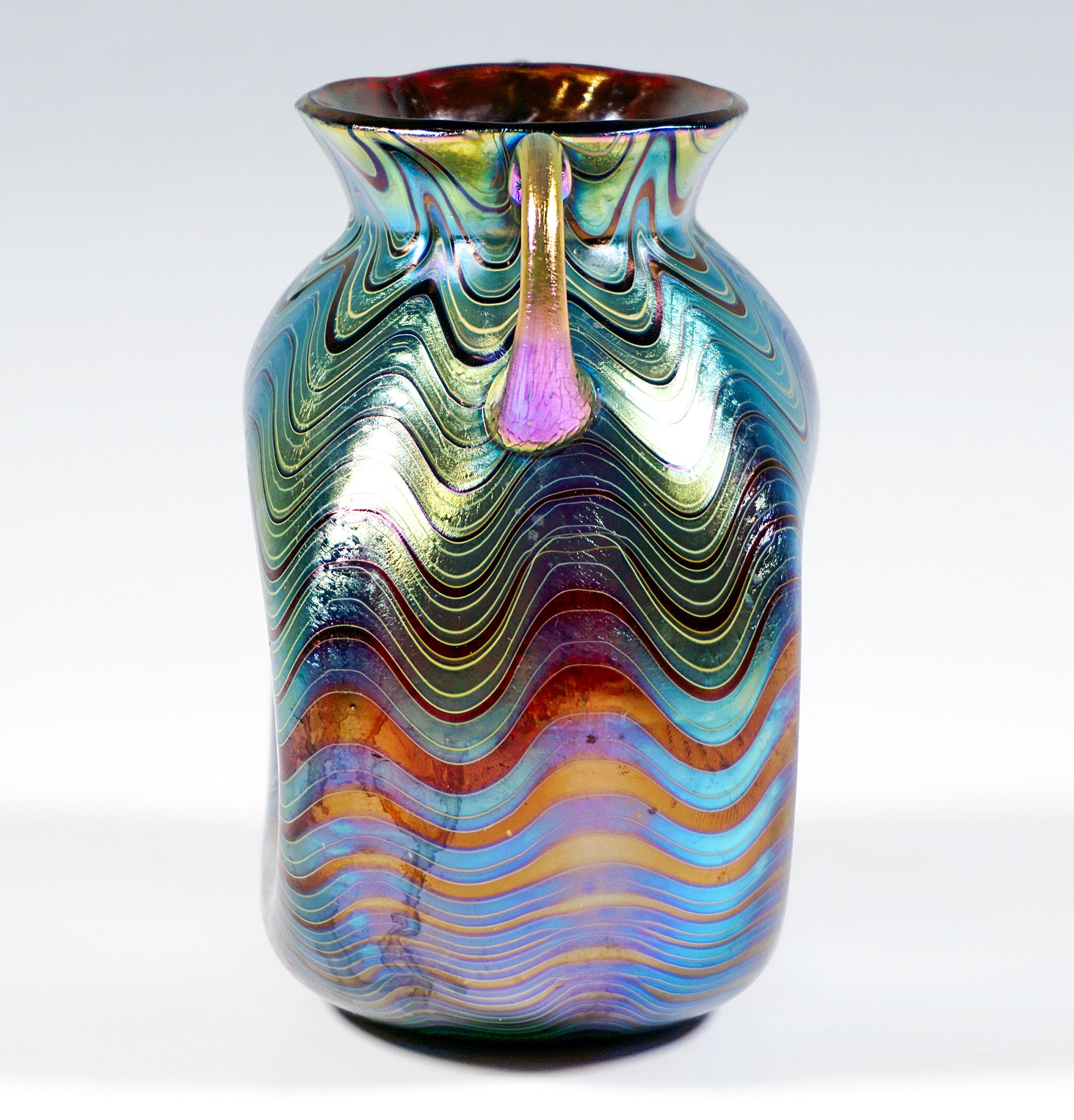 Finest Bohemian Art Nouveau Glass Vase:
Blown into form body in bellied shape with large indentations on the front and back, a short, funnel-shaped, flared neck piece, handles applied to the shoulders and attached to the neck, on a flush stand with