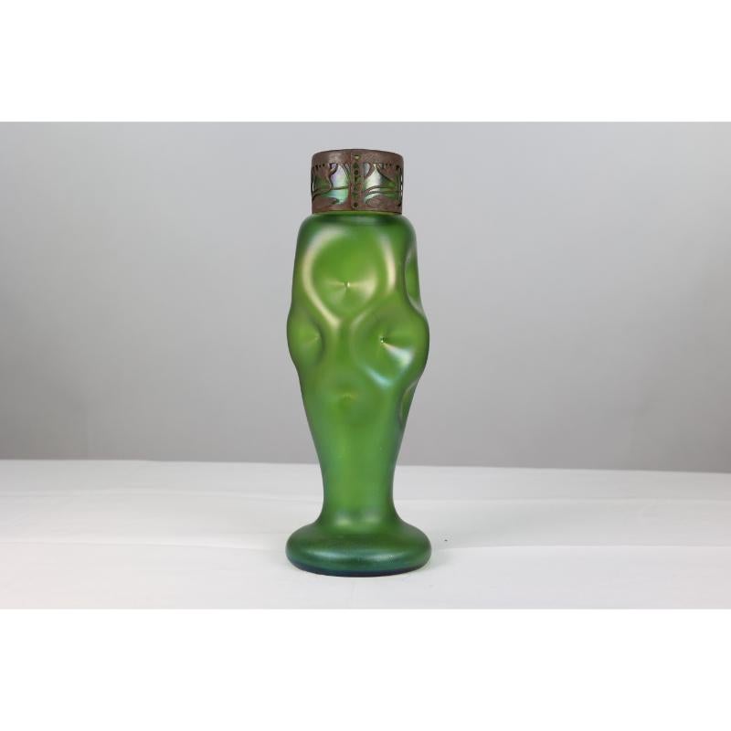 Loetz attributed. A tall Art Nouveau green iridescent vase with a brass collar decorated in foliate Art Nouveau style with dimple decoration to the glass. 
